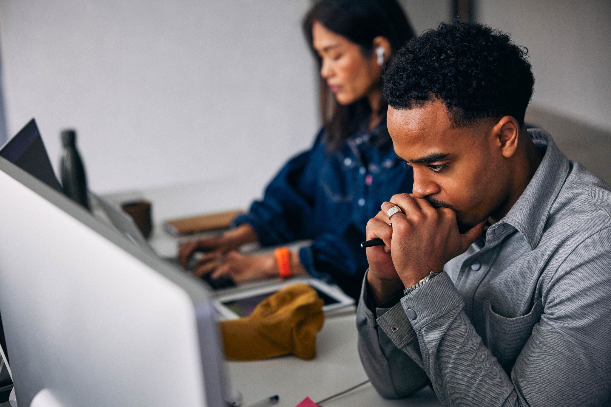High angle view of worried male tech expert sitting at desk with colleague at office