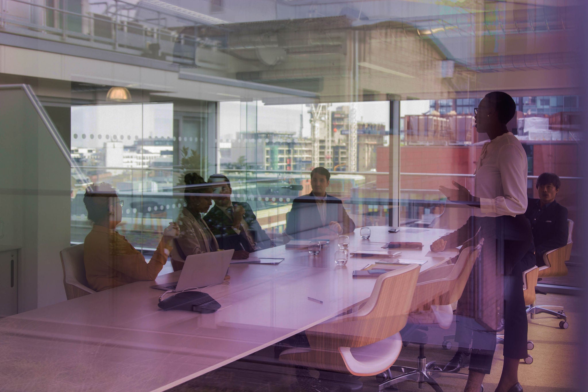 People meeting in a modern glass-walled conference room
