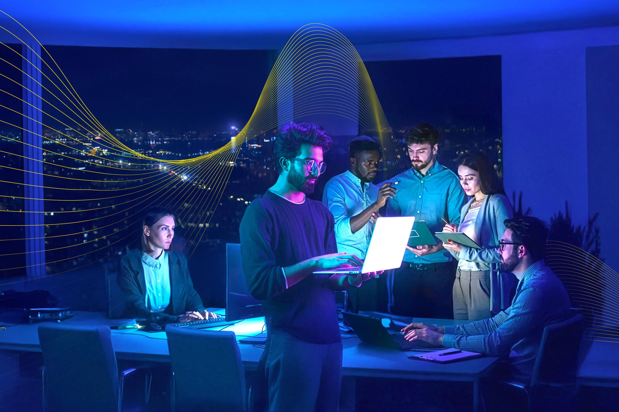 Male developer holds a laptop computer in a meeting with development team