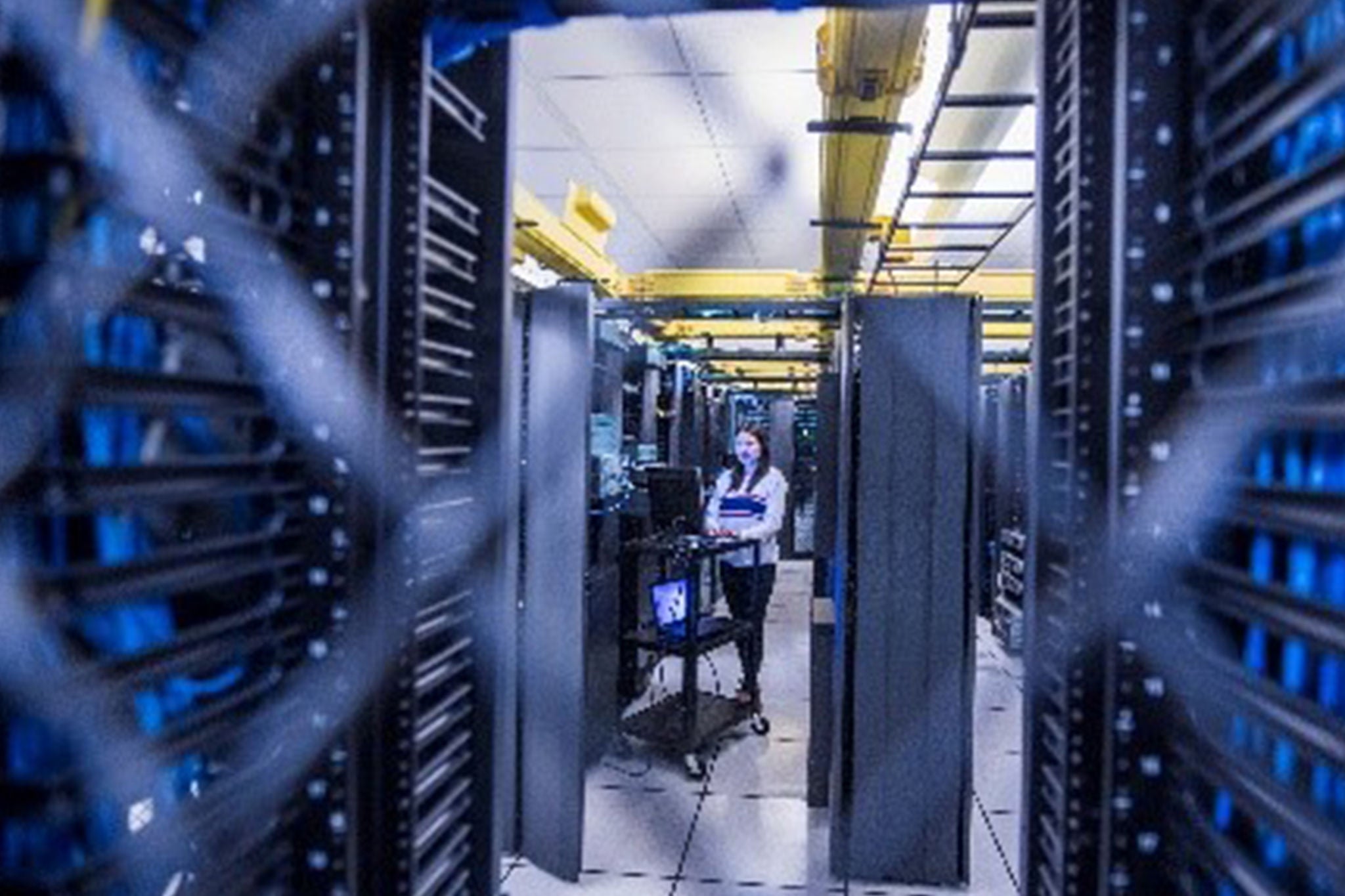 Engineer working in a server room aisle