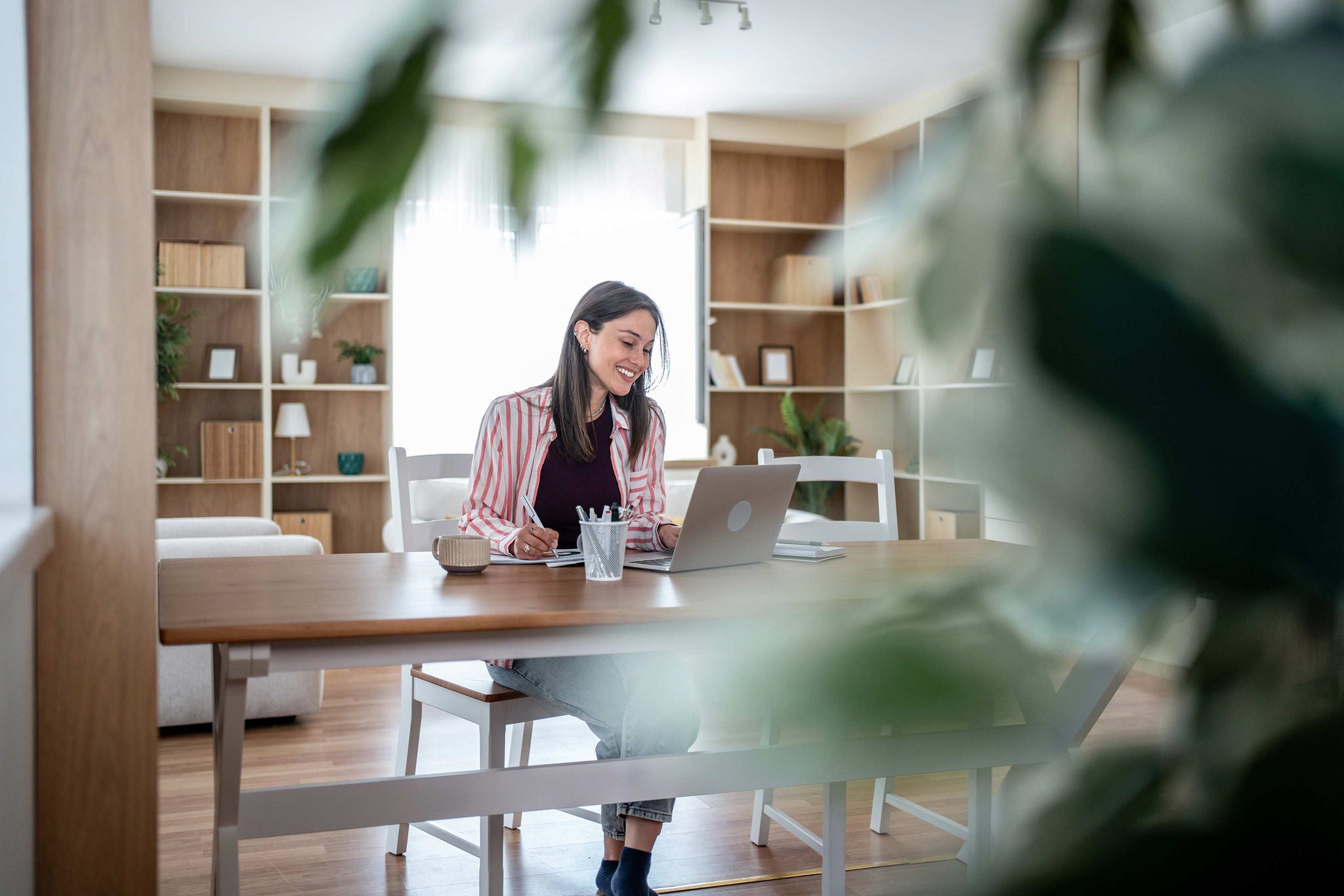 Mann arbeitet von zu Hause aus an Laptop und Desktop