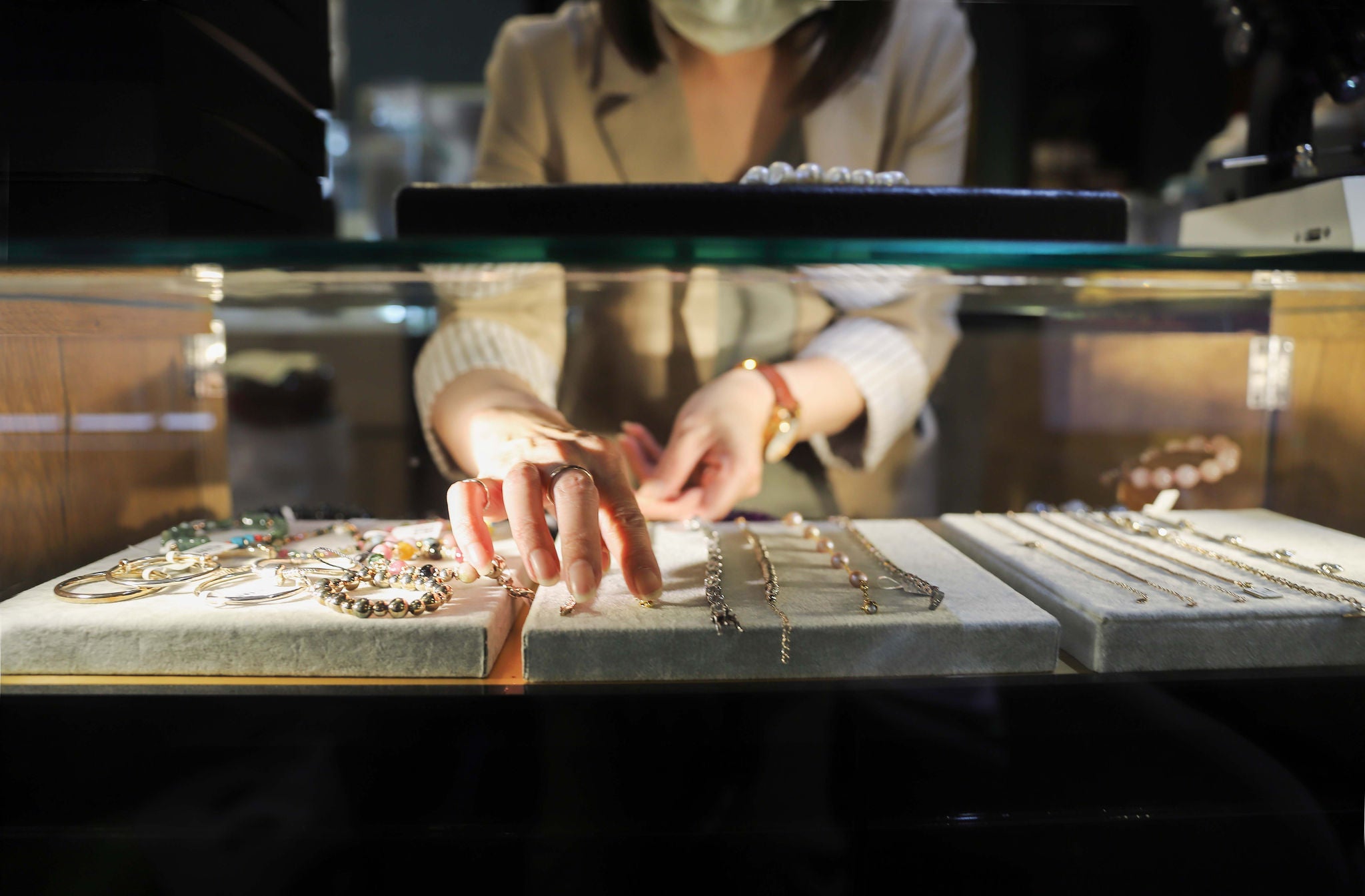 The female clerk placed the jewelry on the counter