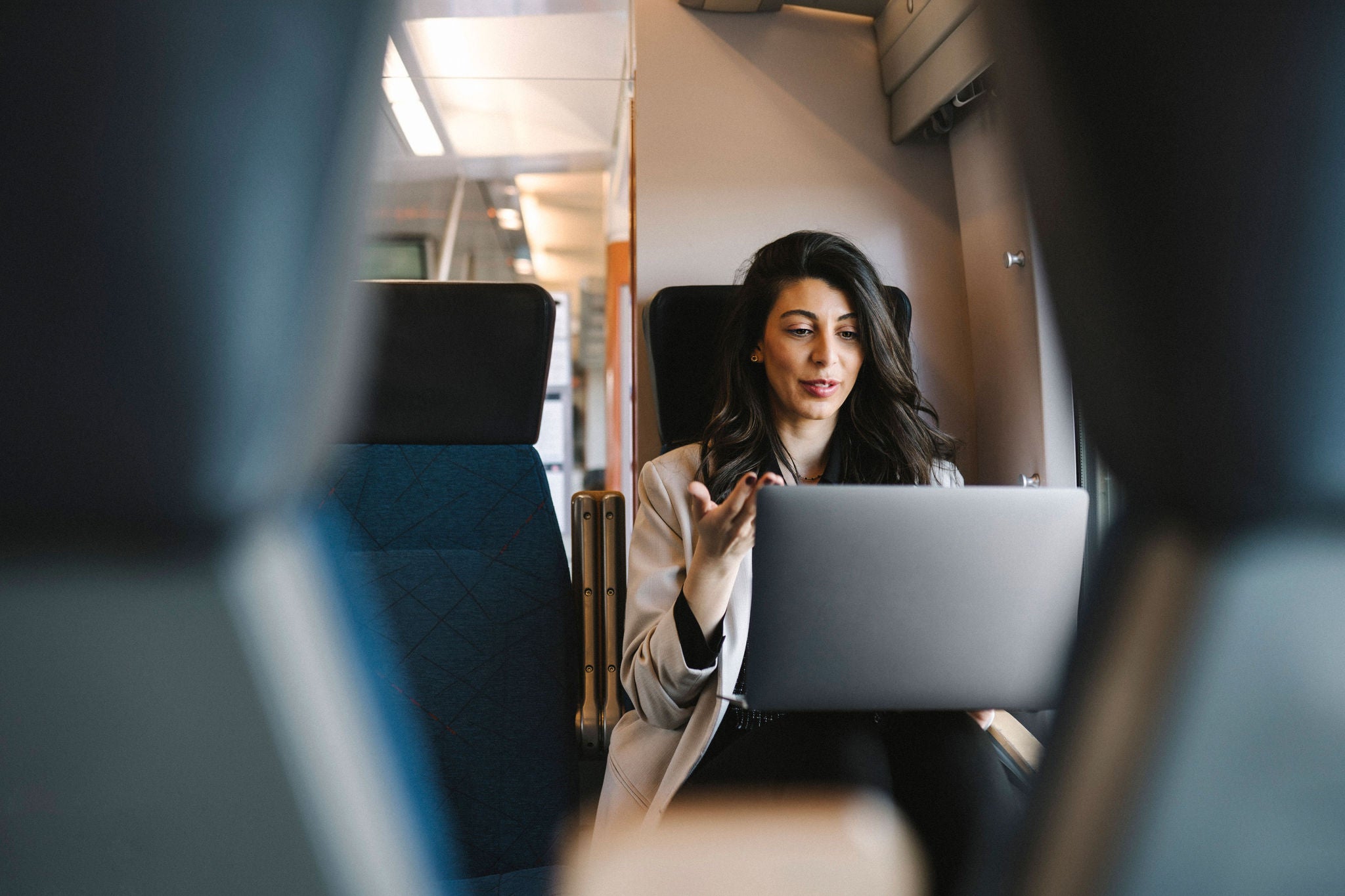 young woman talking on her laptop while on a train