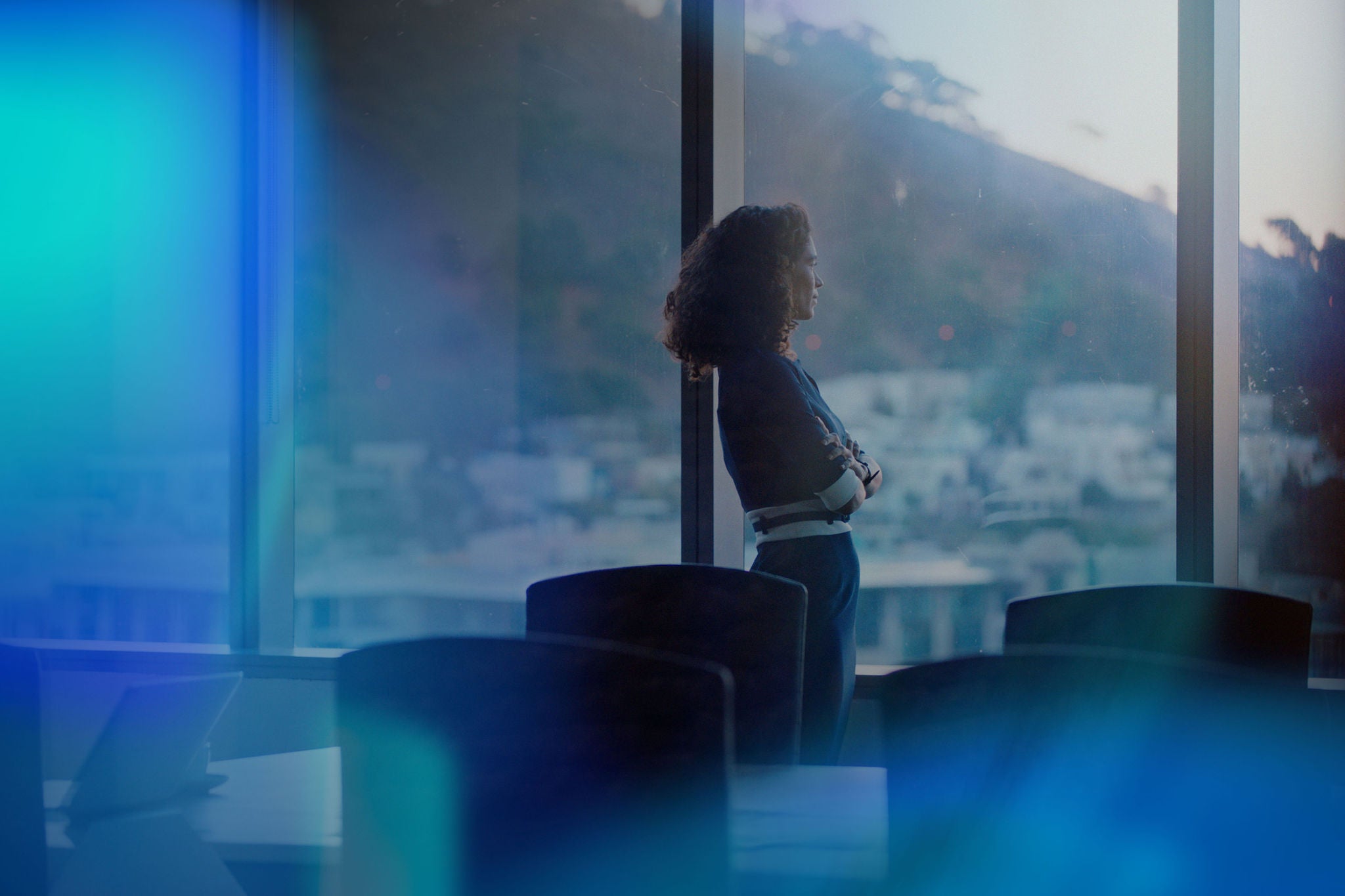 Professional standing by office window overlooking cityscape