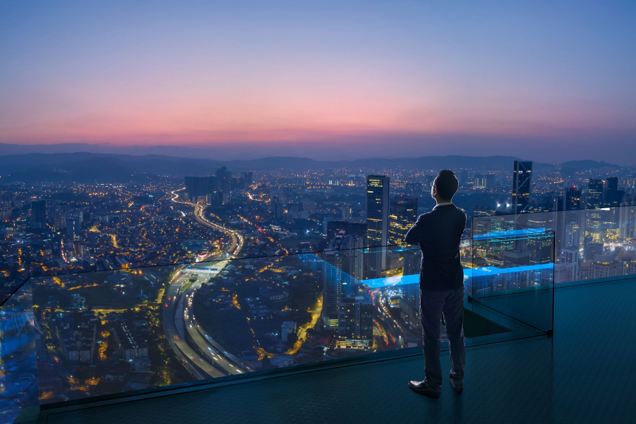 Businessman standing on open roof top balcony