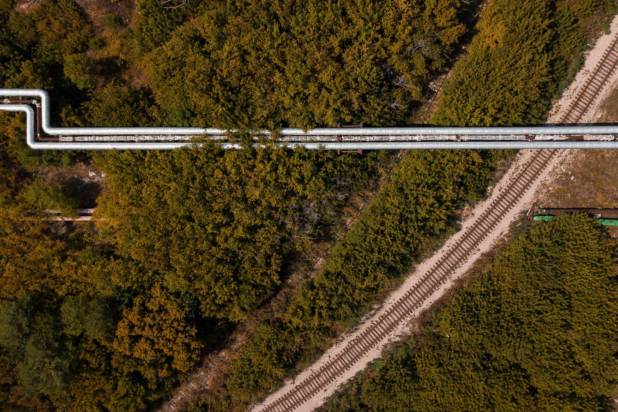 Luftaufnahme einer Kreuzung von Eisenbahnstrecke und Pipeline.