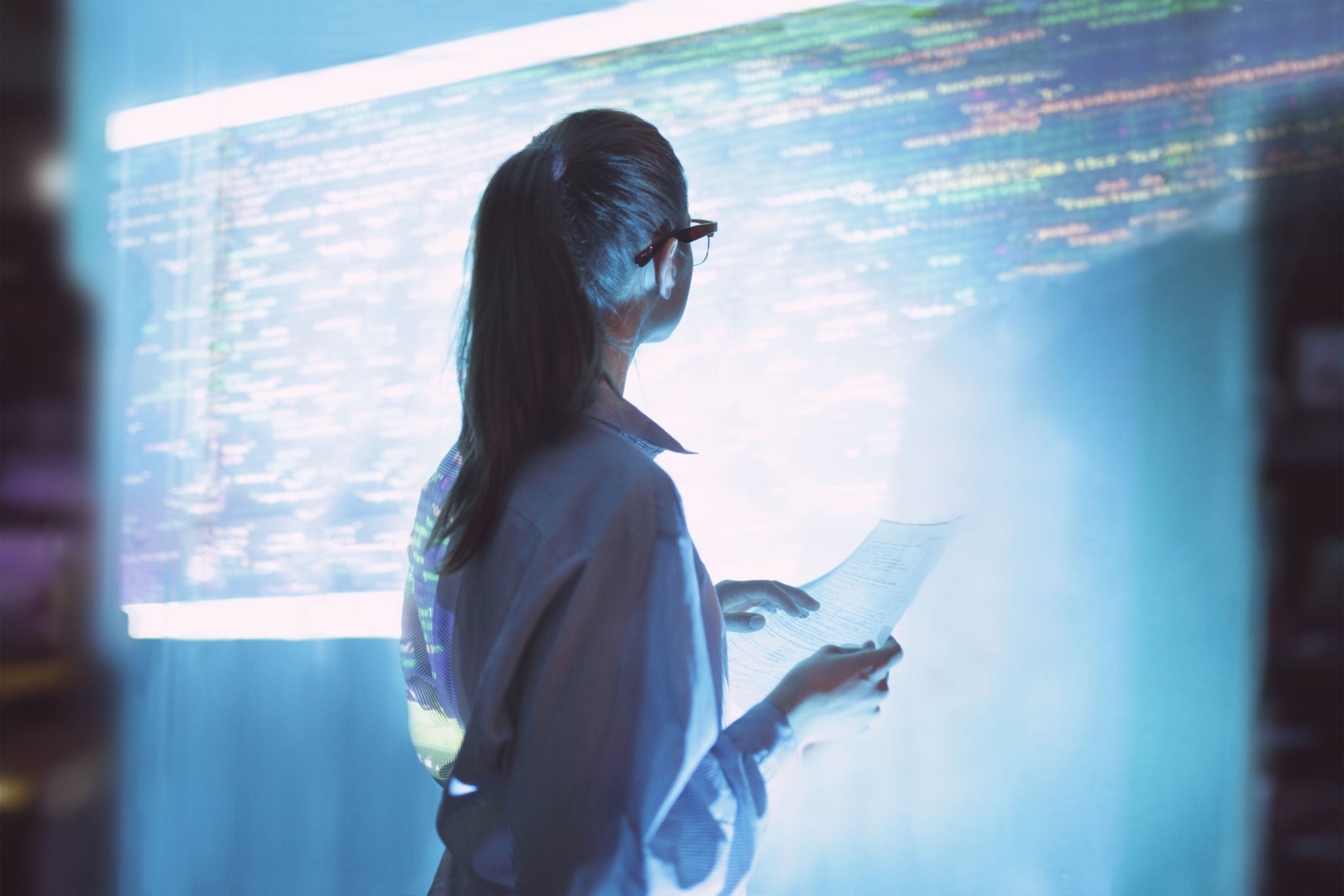  Woman looking at projected code on office wall