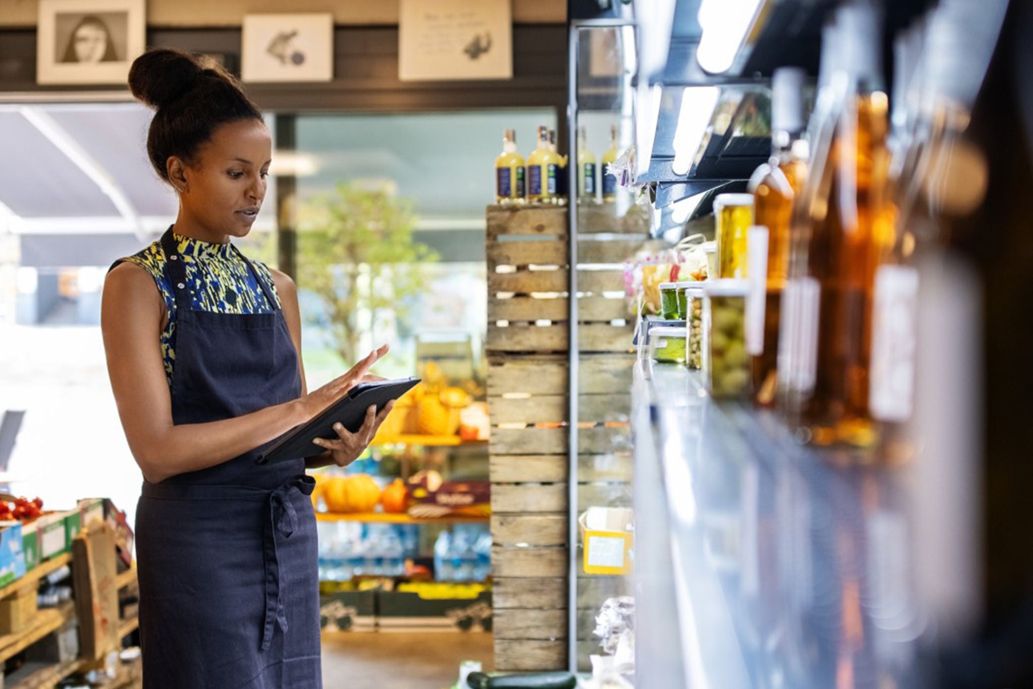 Worker using a tablet in a grocery store aisle