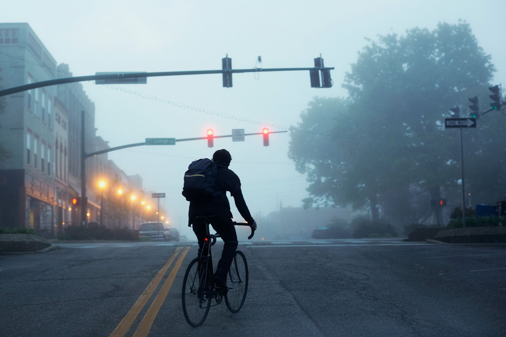 adfahrer im morgendlichen Nebel an einer ruhigen Kreuzung der Innenstadt