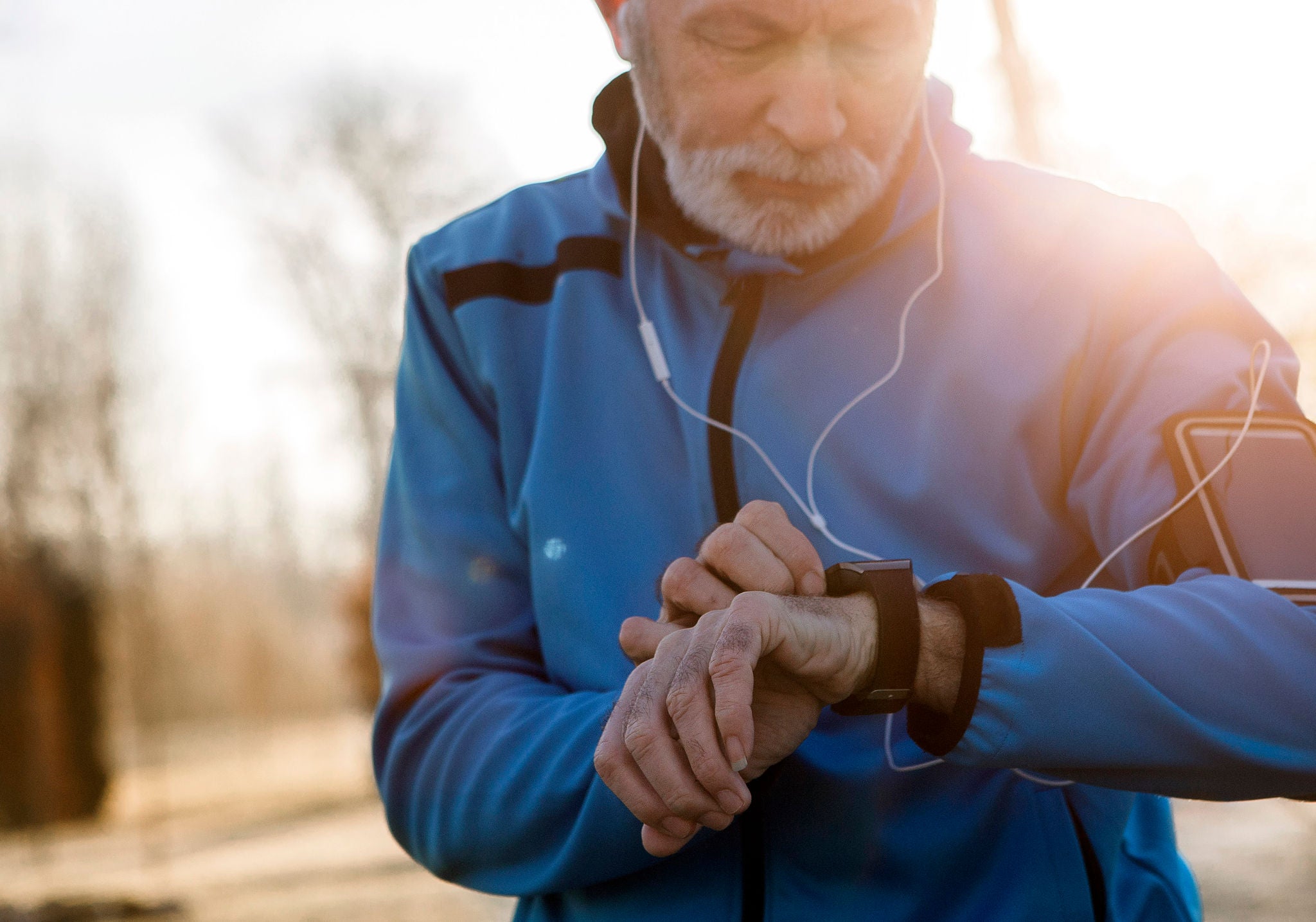 Elderly Man using Smart Watch measuring heart rate during walk