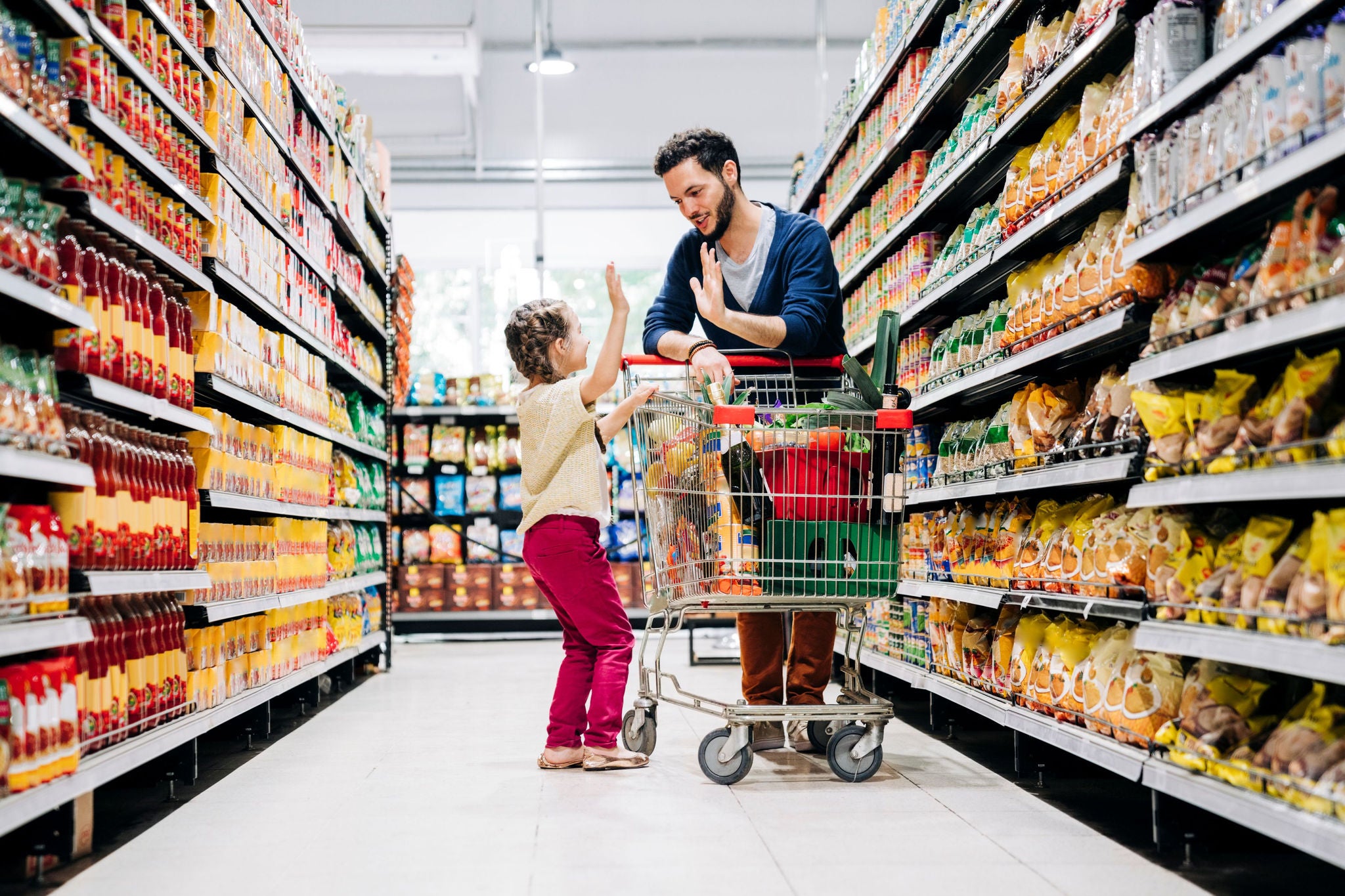 Personne et enfant faisant des courses dans un supermarché