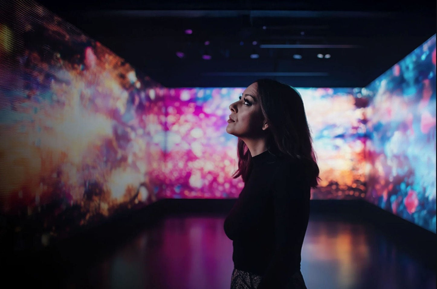 a woman admiring a digital exhibition in a musem