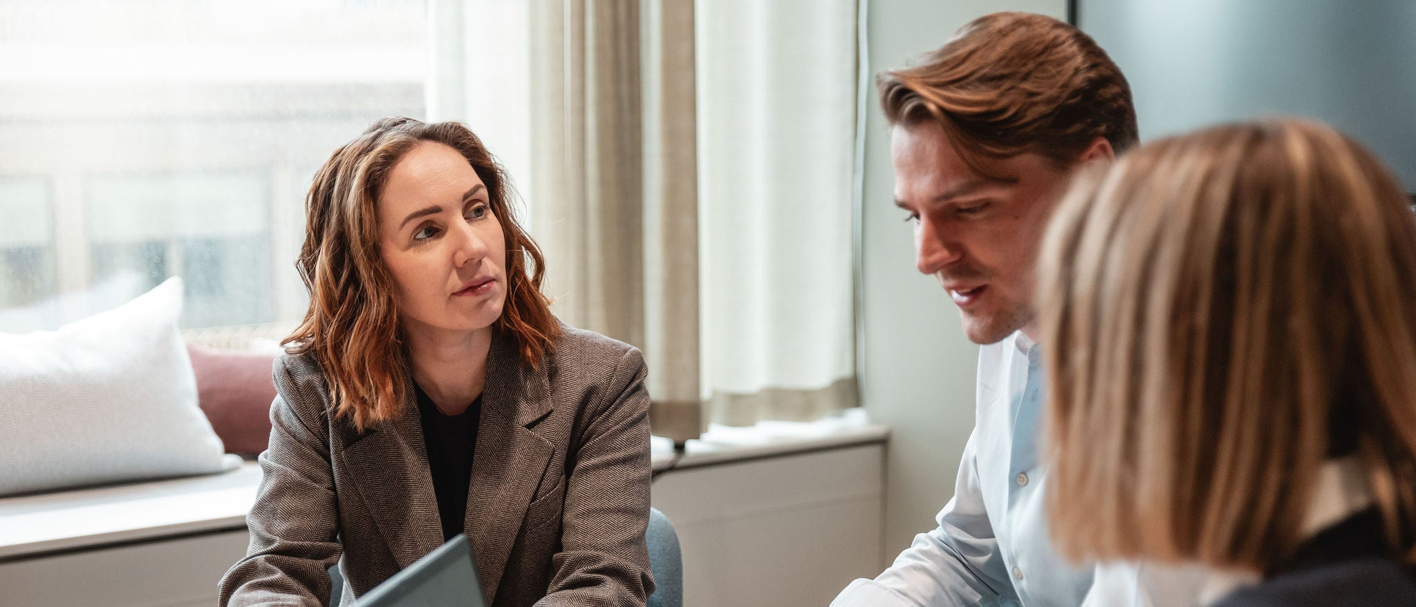 Professionals discussing work together during focused office meeting