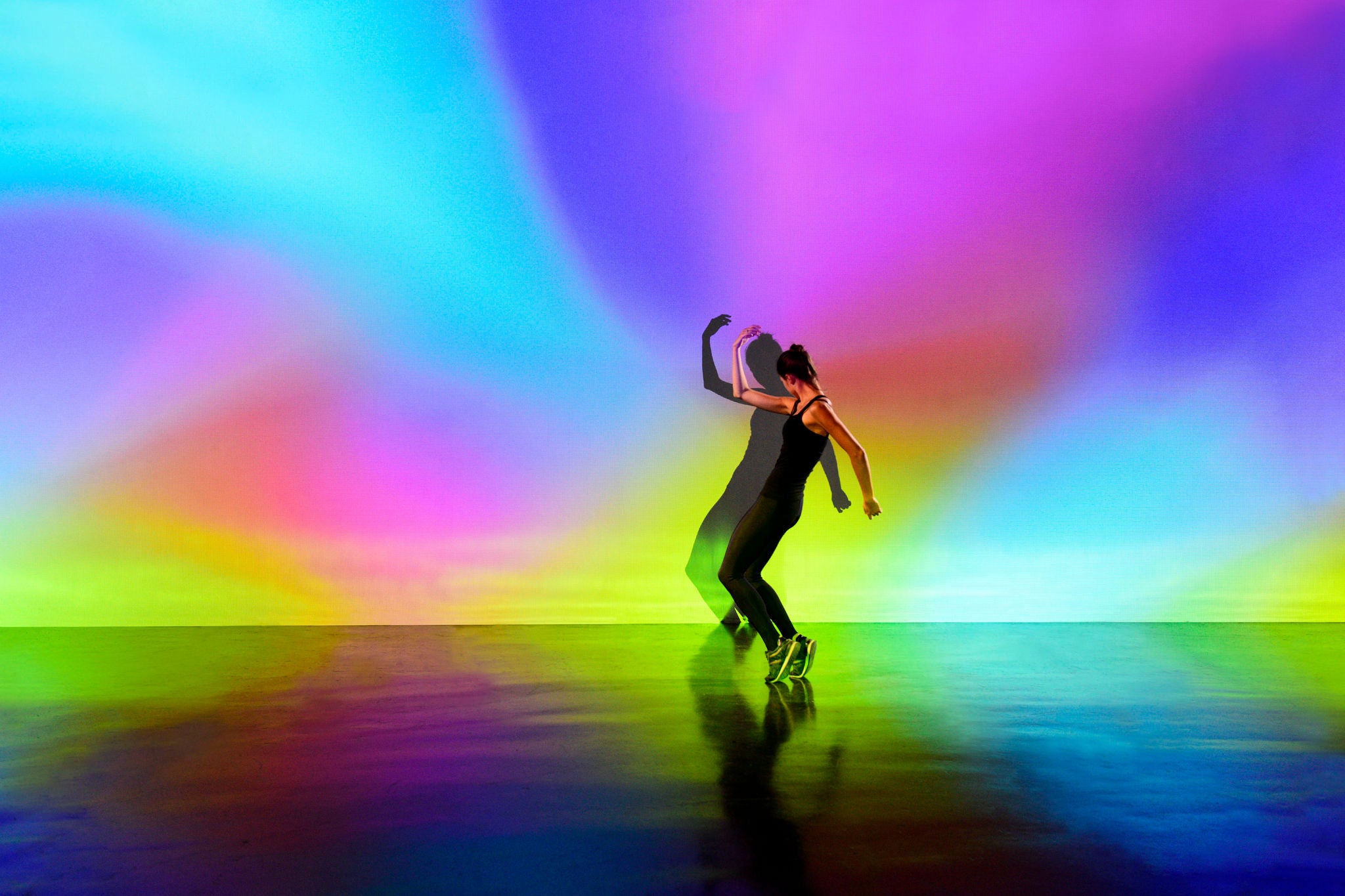 Girl dancing in a studio, lit with multiple colours