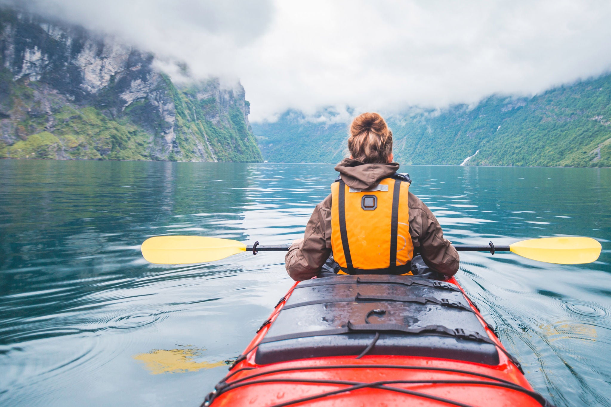 Woman kayaking in fjord in Norway