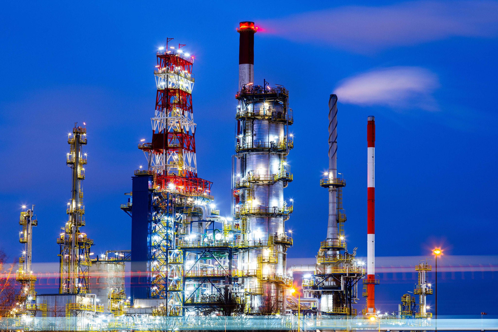 Raffinerie illuminee la nuit avec structures metalliques