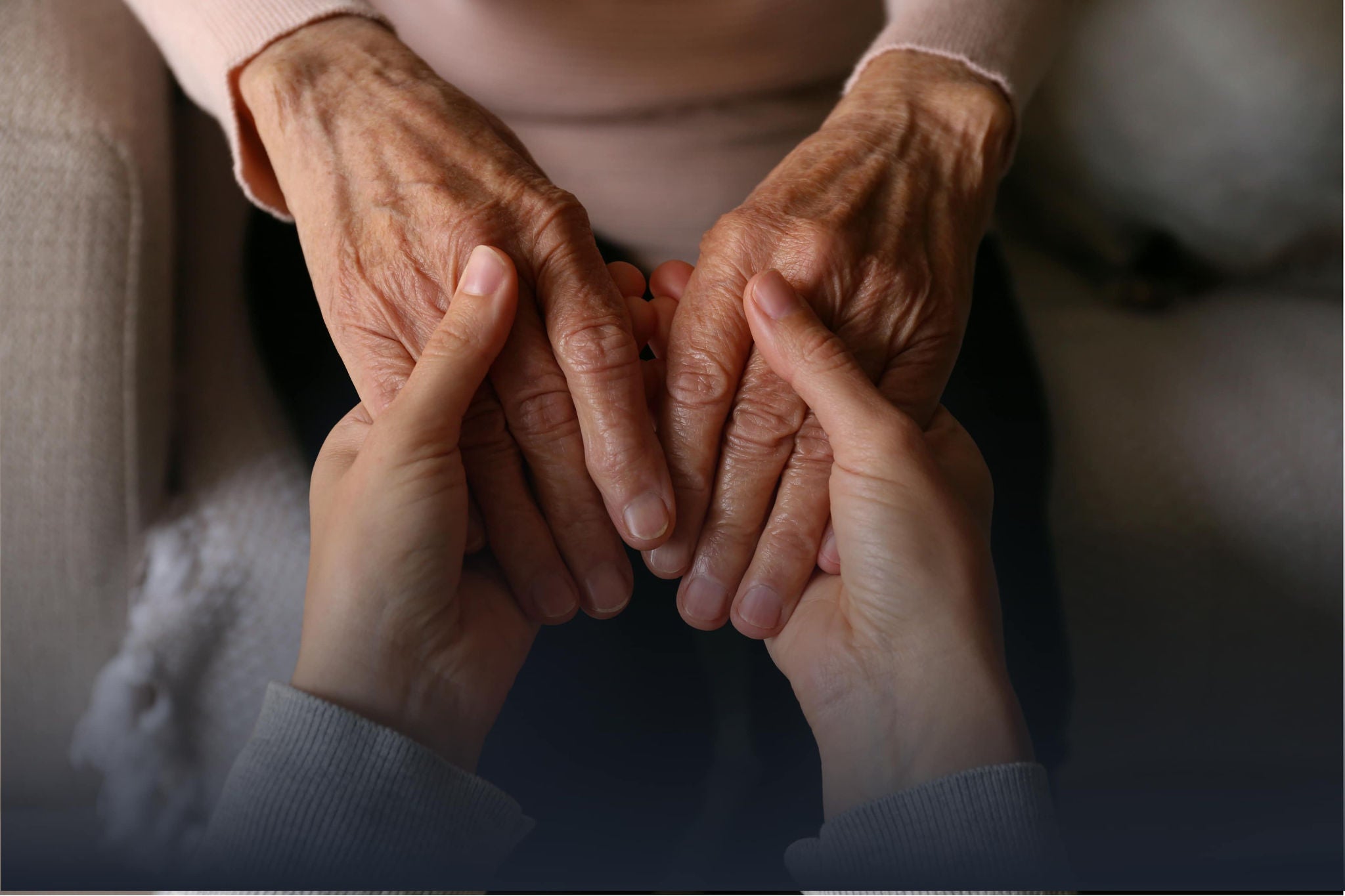 A smiling young woman with headphones and folders, standing outdoors on a college campus.