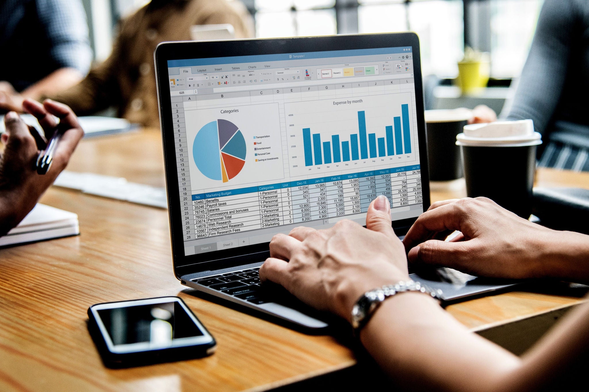 person in meeting looking at data on laptop