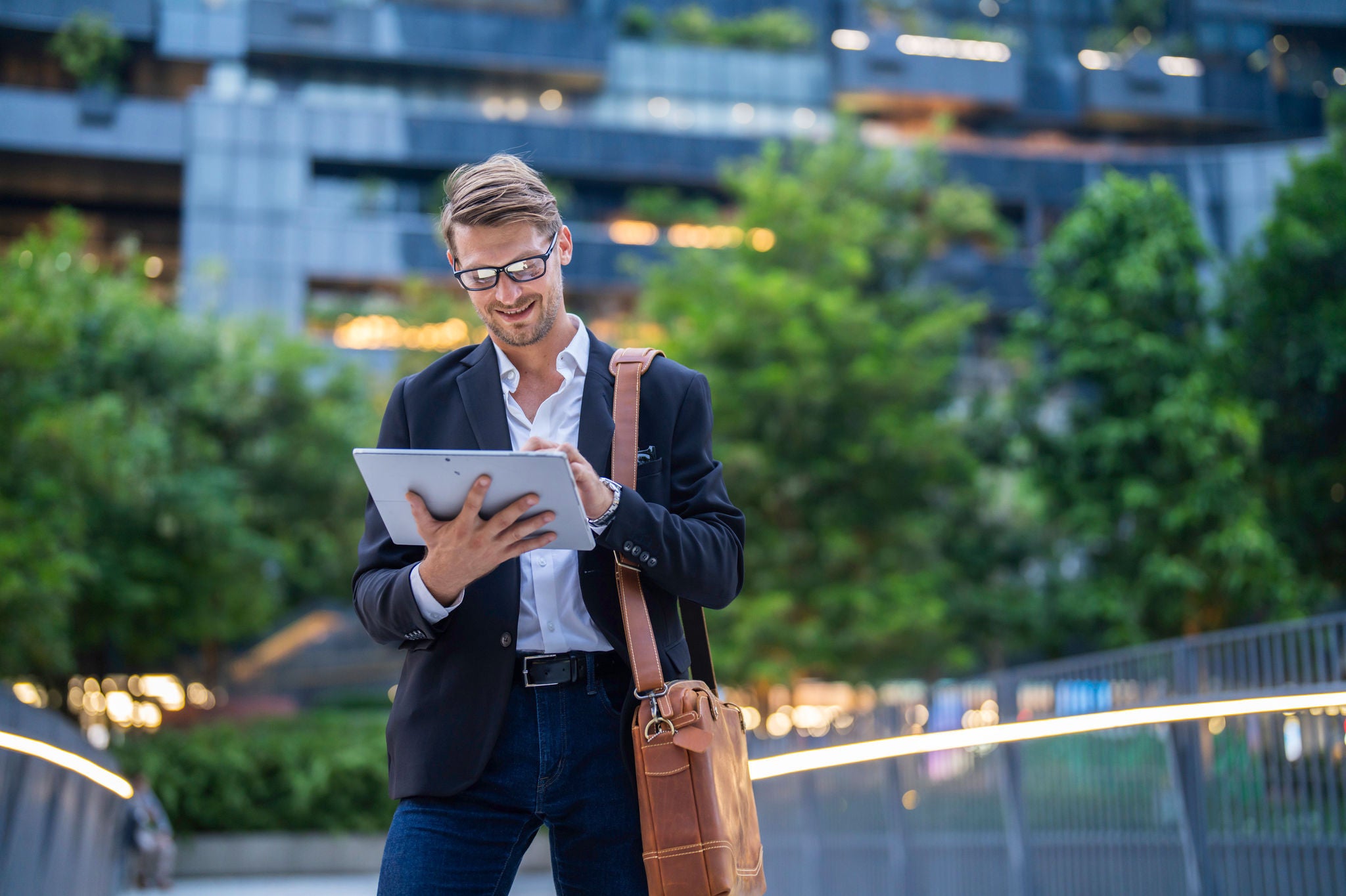 Portrait of businessman in glasses holding tablet