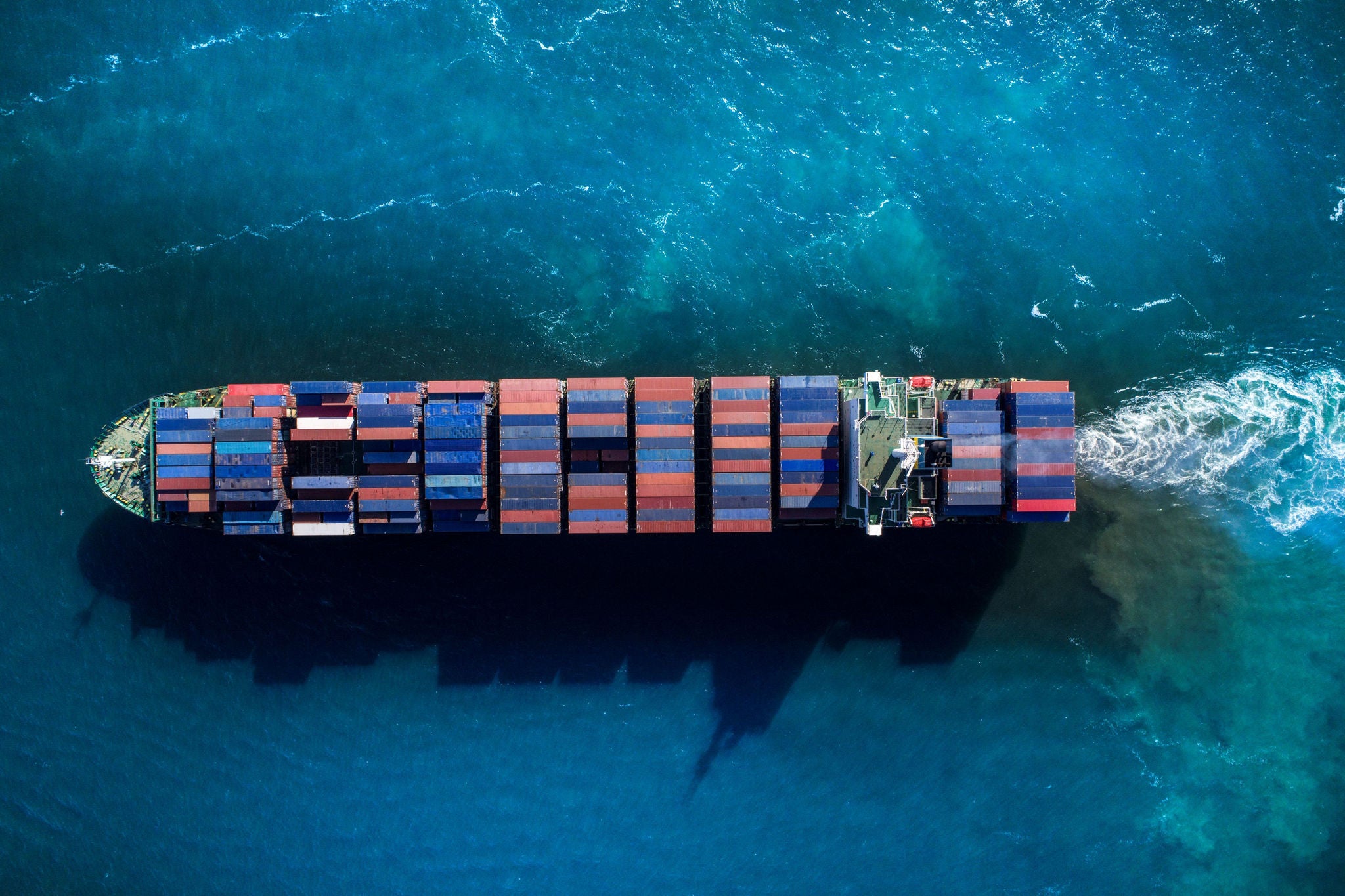 Konténerszállító hajó nyílt tengeren, amely az import–export folyamatok jelentőségét szimbolizálja.