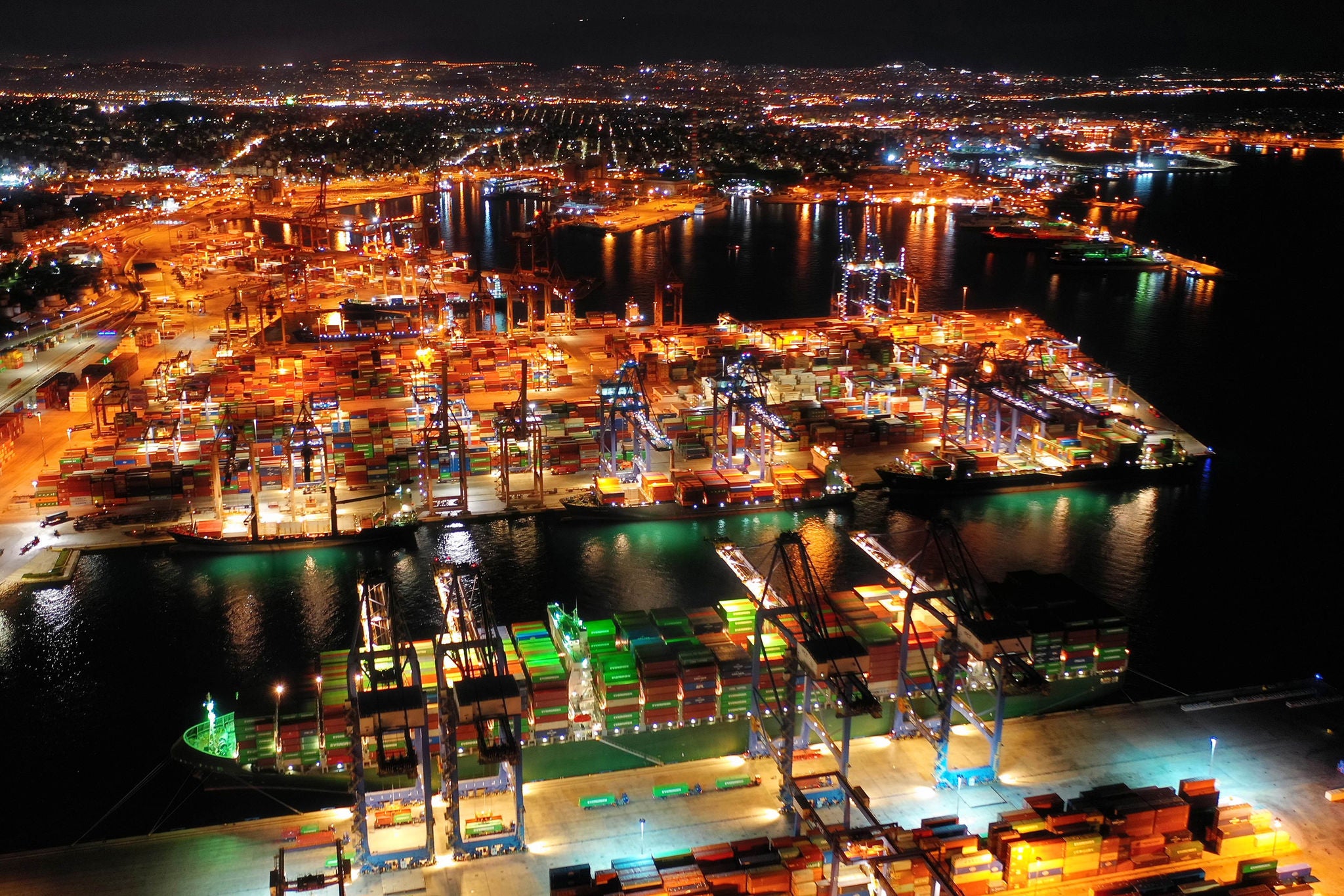 Aerial drone night shot of illuminated loading/unloading container terminal