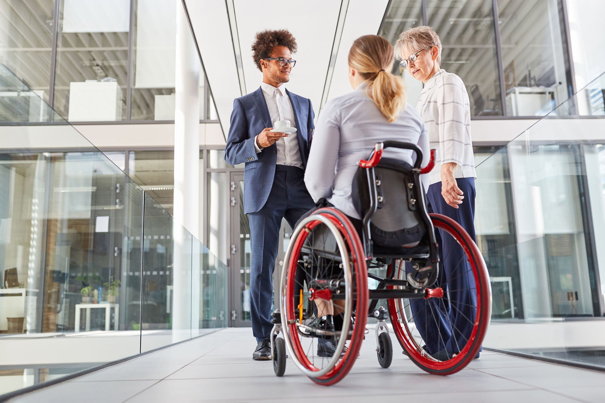 Businesswoman in a wheelchair talking to colleagues