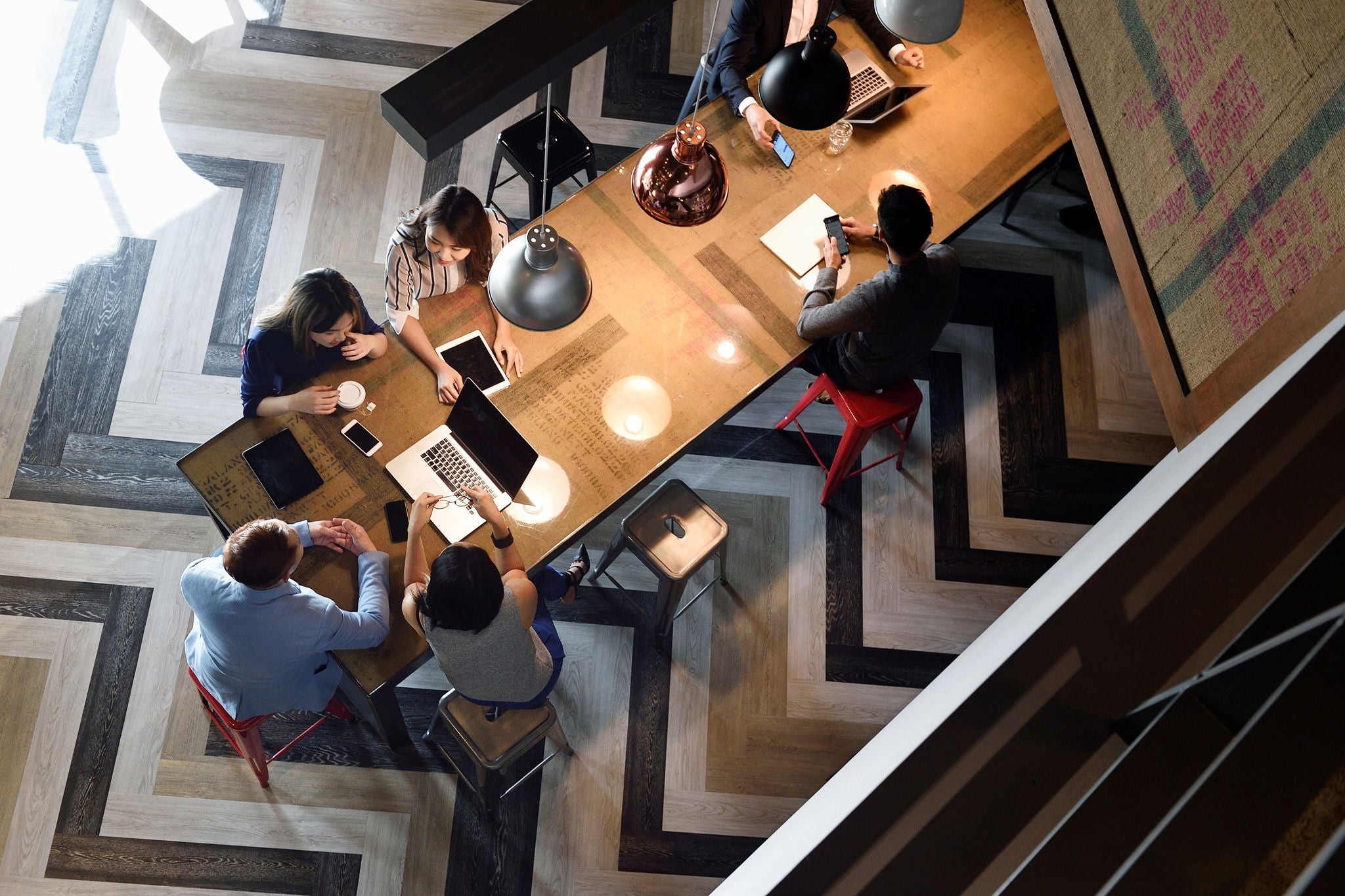 Team members collaborating and sharing ideas at a long conference table.