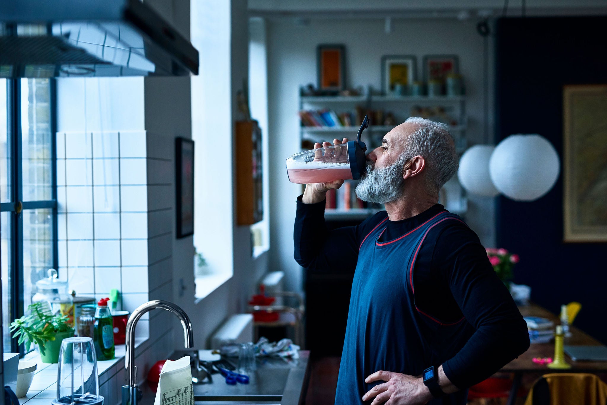 Man drinking sport drink sink kitchen