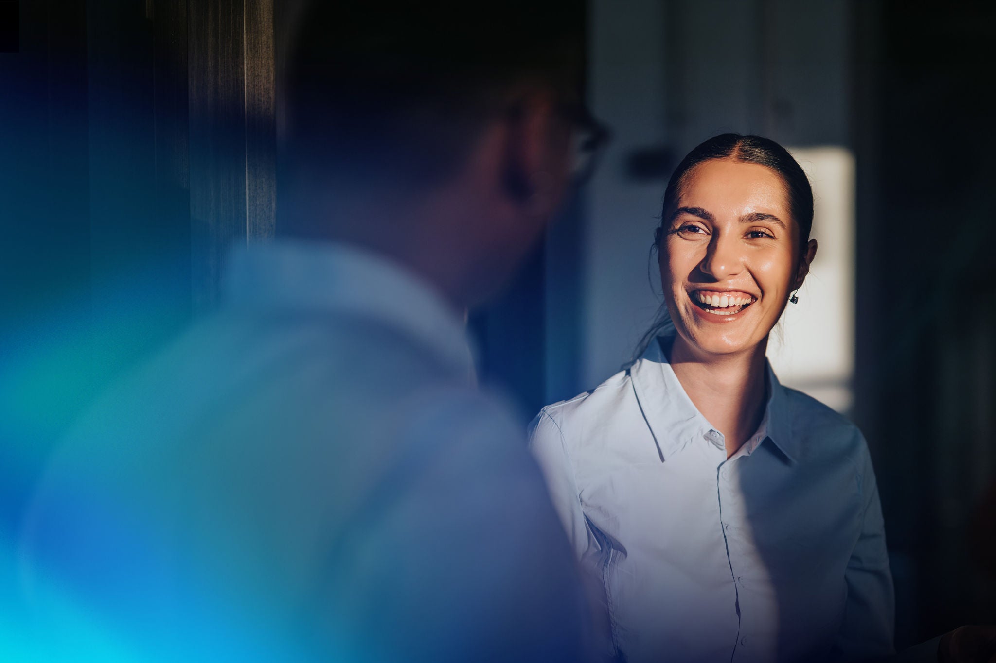 Professional smiling during conversation in an office setting