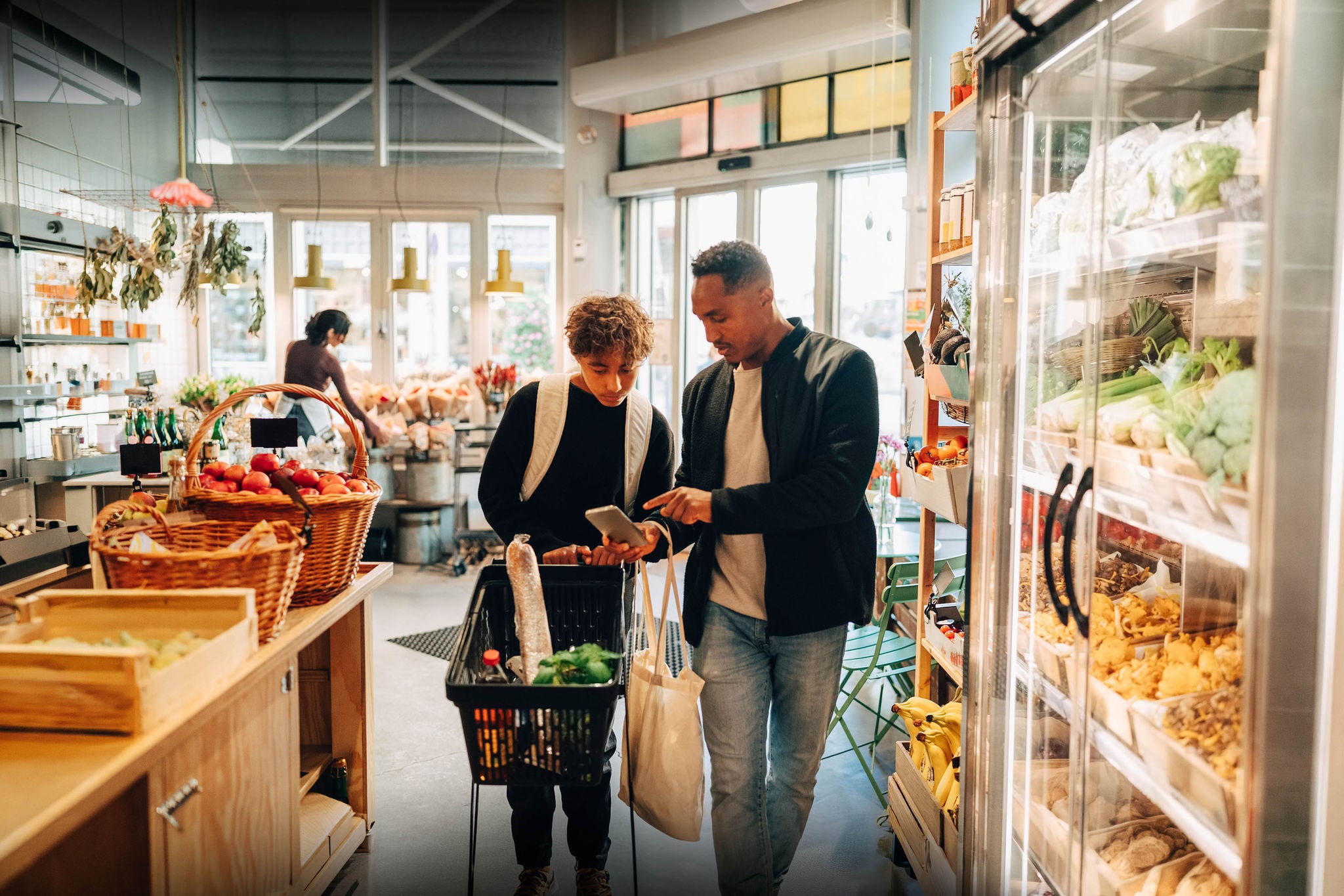 Father and son checking a shopping list on a smartphone while grocery shopping 