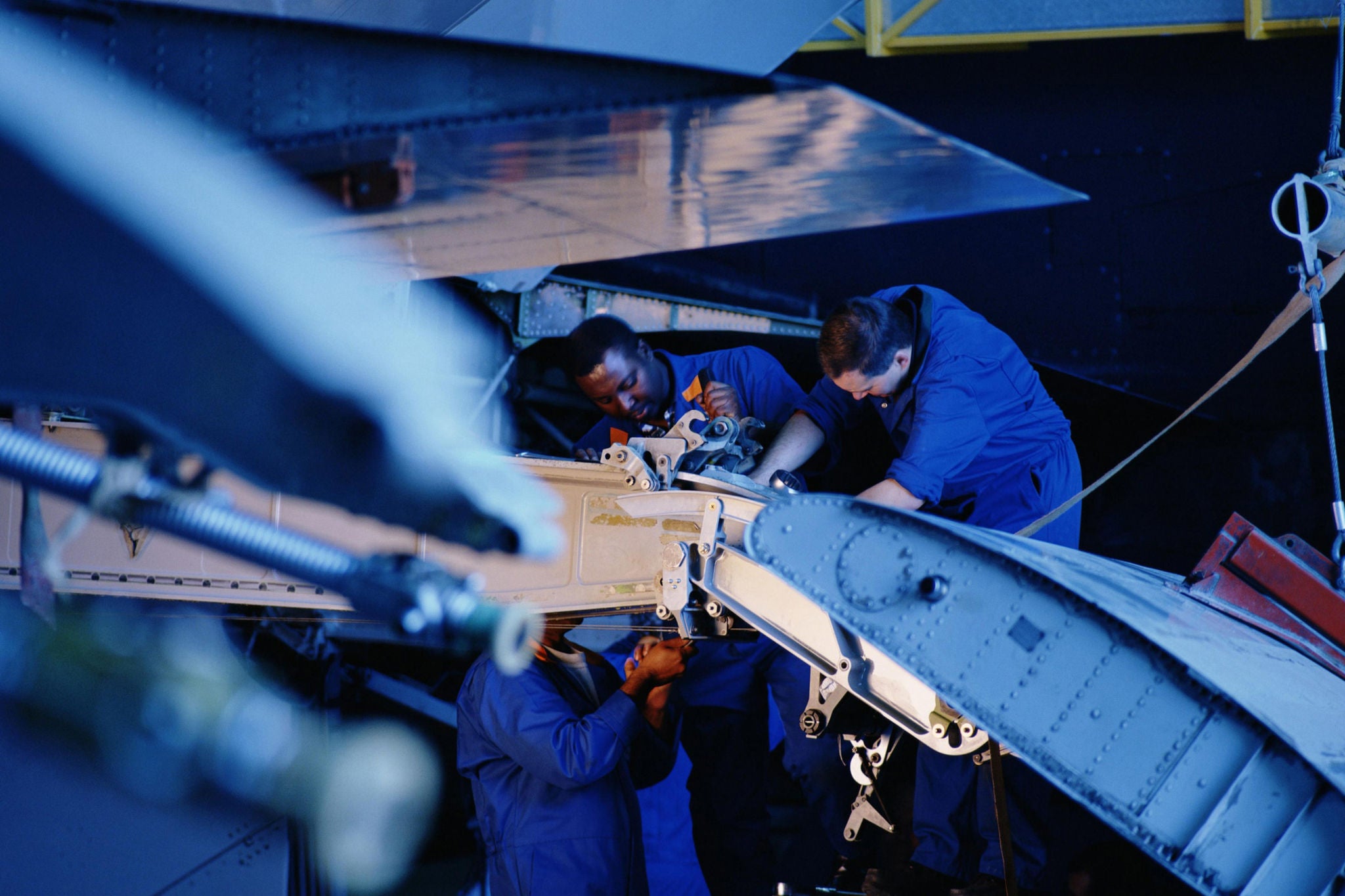 Aircraft maintenance crew inspecting landing gear assembly