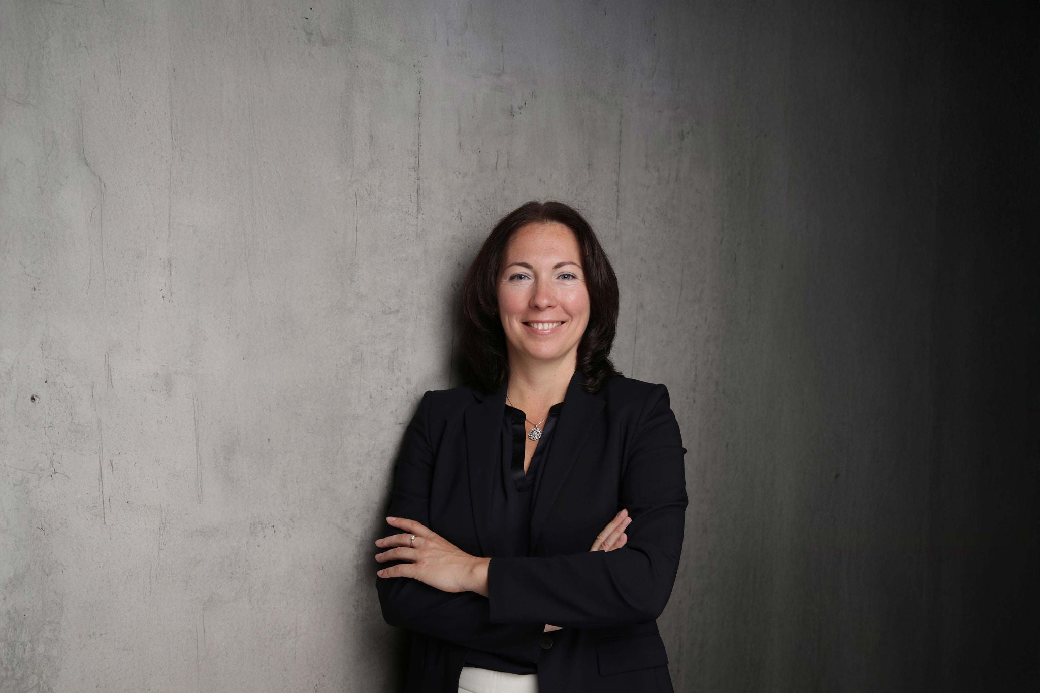 Porträt einer Geschäftsfrau vor grauer Wand