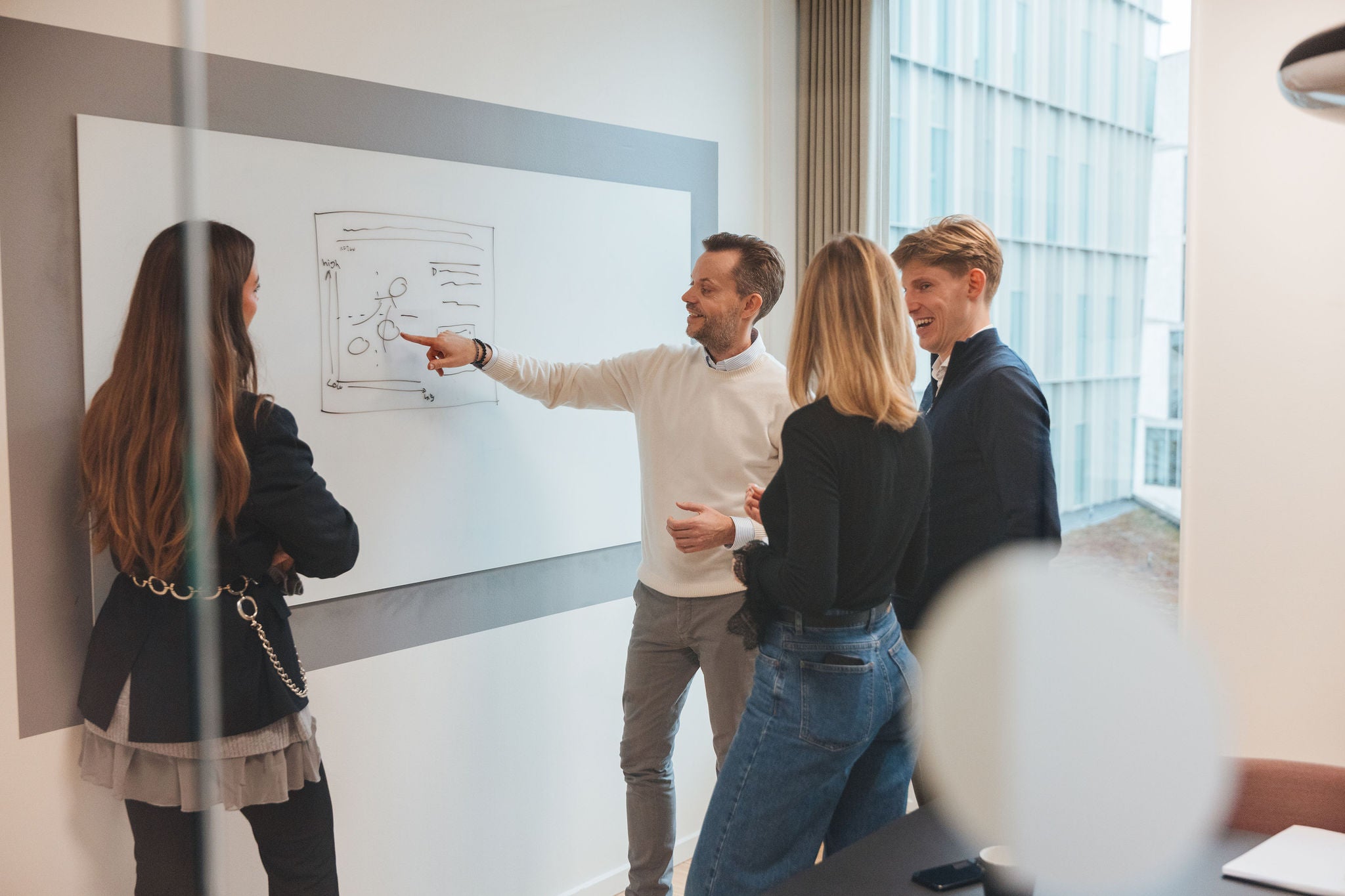 Team reviewing strategy on whiteboard during office collaboration