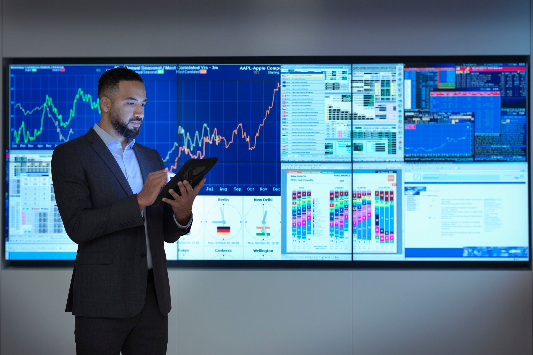 Businessman using digital tablet in front of digital charts