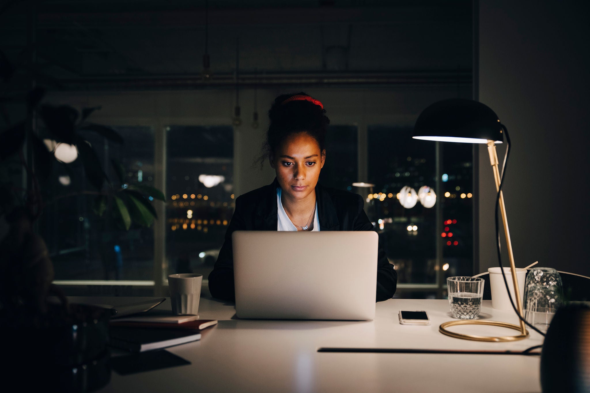 Forretningskvinde arbejder ved computer om aftenen