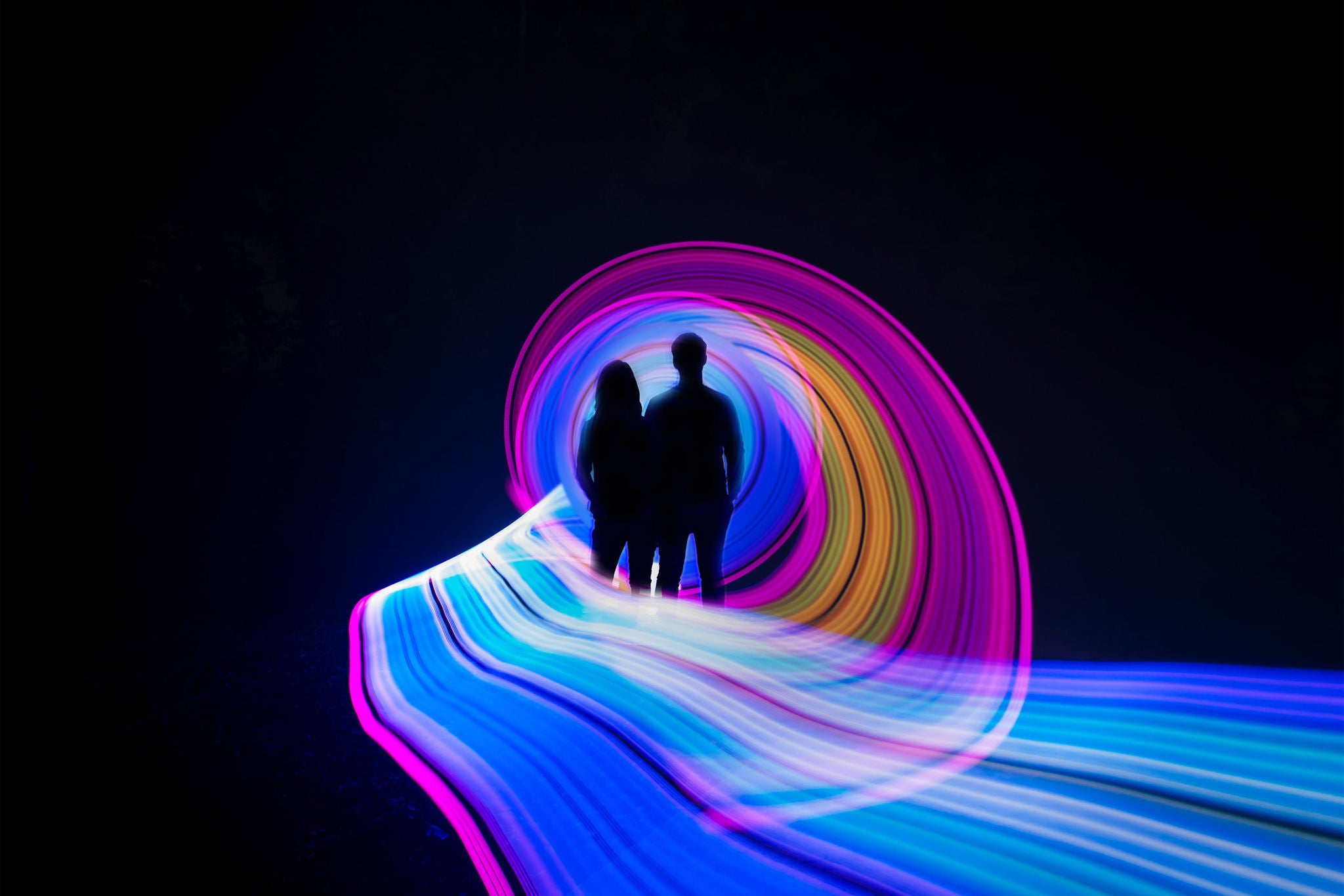 One person standing alone against beautiful color circle LED light painting as the backdrop