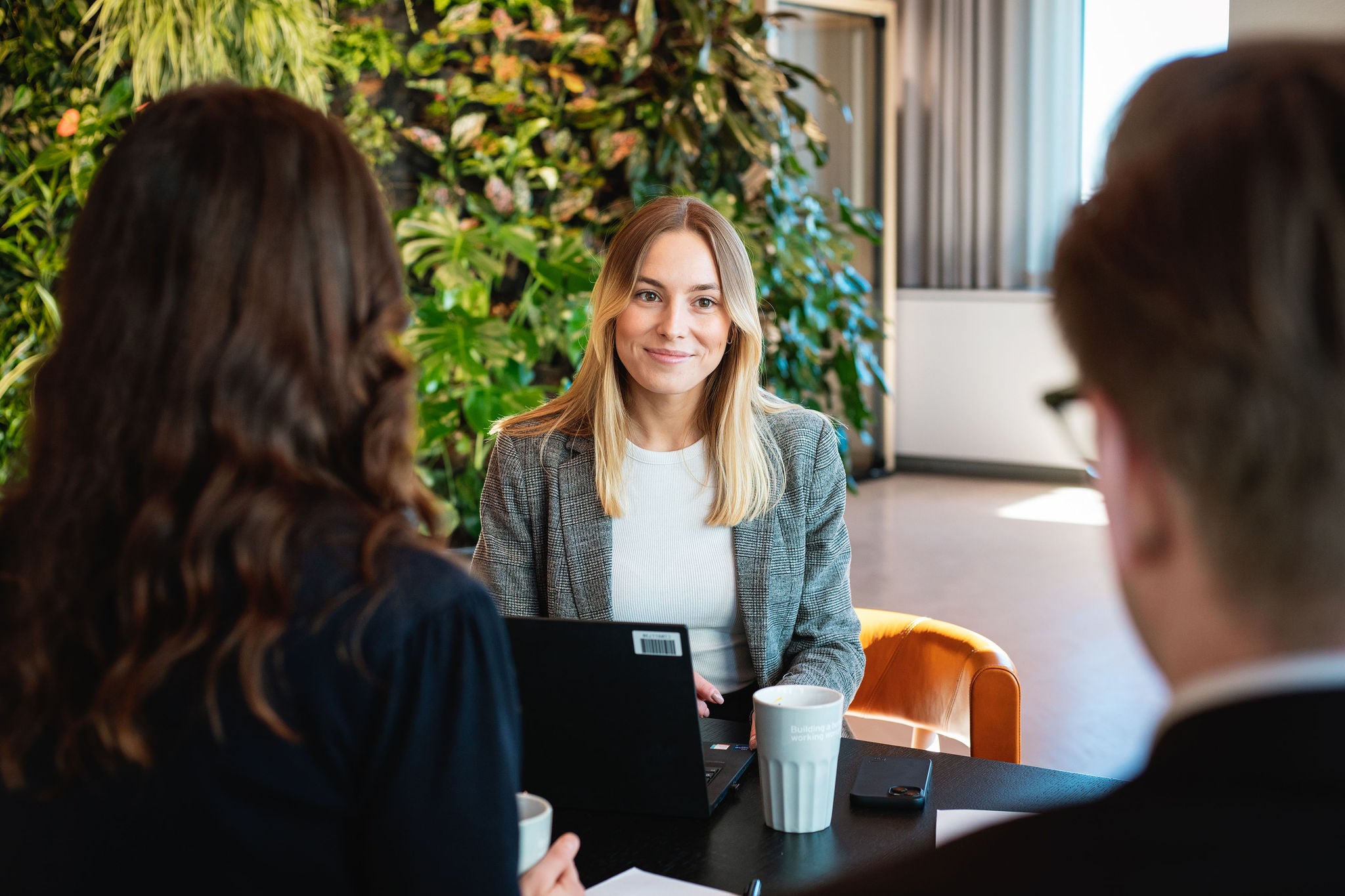 Professionals seated around a table in the EY Stockholm office, discussing work in a meeting area.