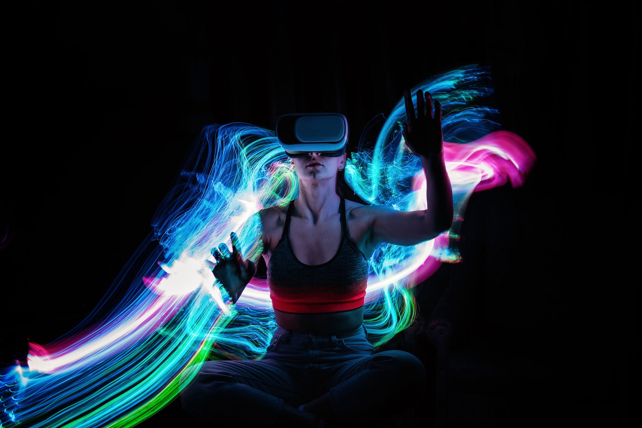 Frau mit VR-Brille spielt AR-Augmented-Reality-NFT-Spiel mit neonfarbenen Unschärfebalken.