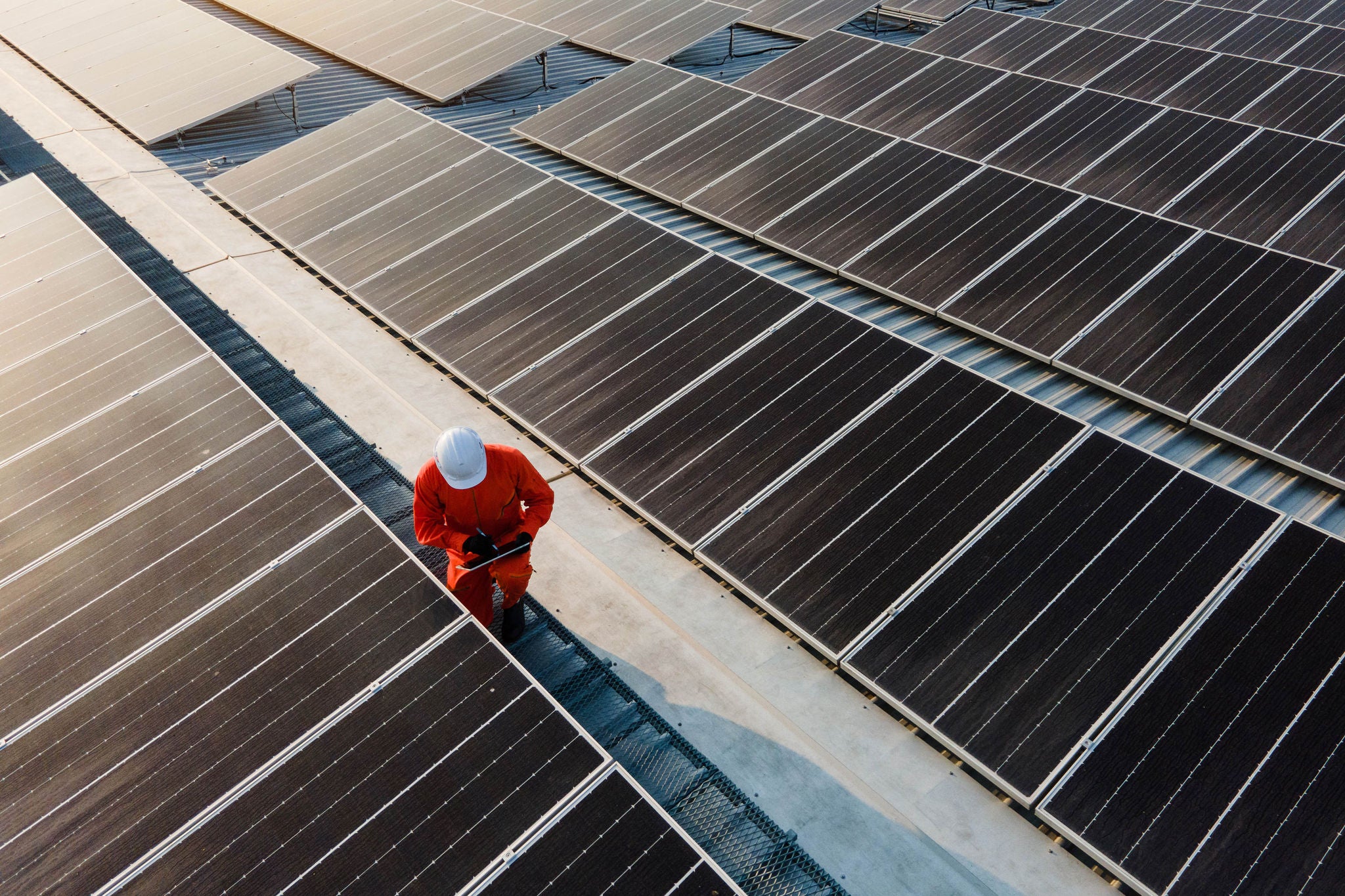 Byggarbetare står på tak med solceller