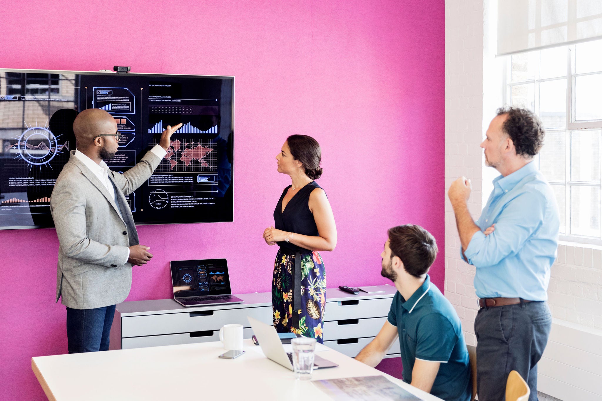 Businessman using graphs on screen in business meeting