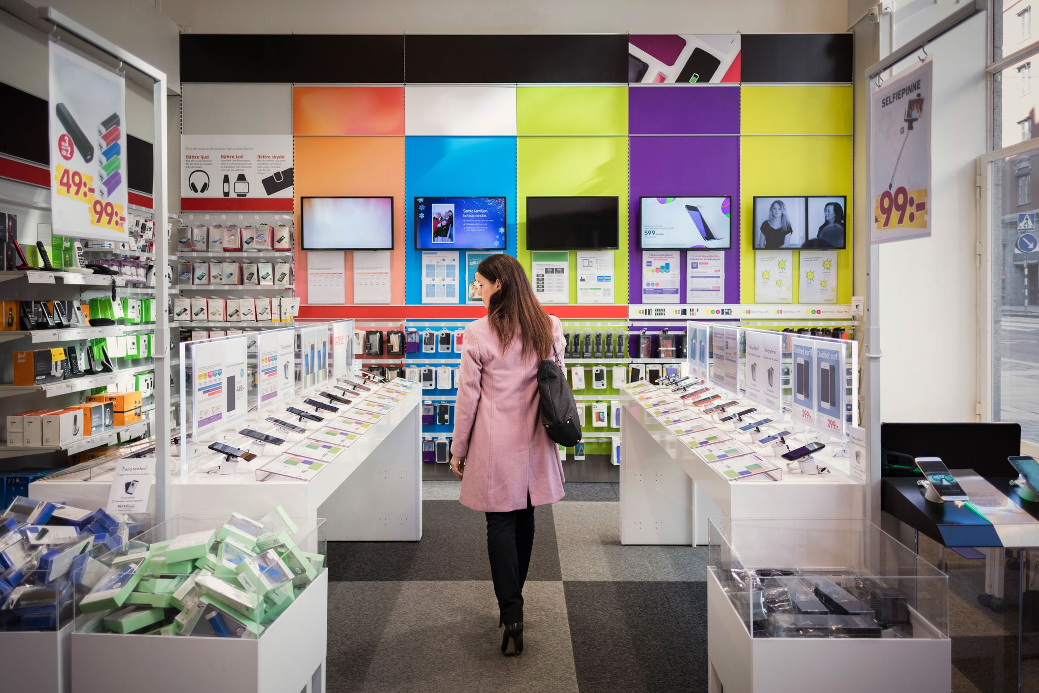 Une personne regardant des accessoires électroniques dans un magasin éclairé