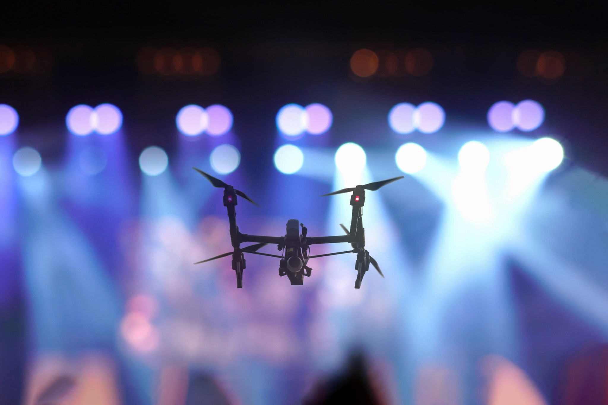 Closeup silhouette of Drone flying for taking video of Concert 