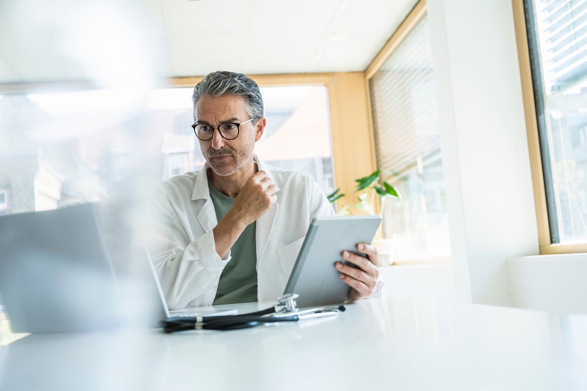 Man working on laptop while sitting in kitchen at home