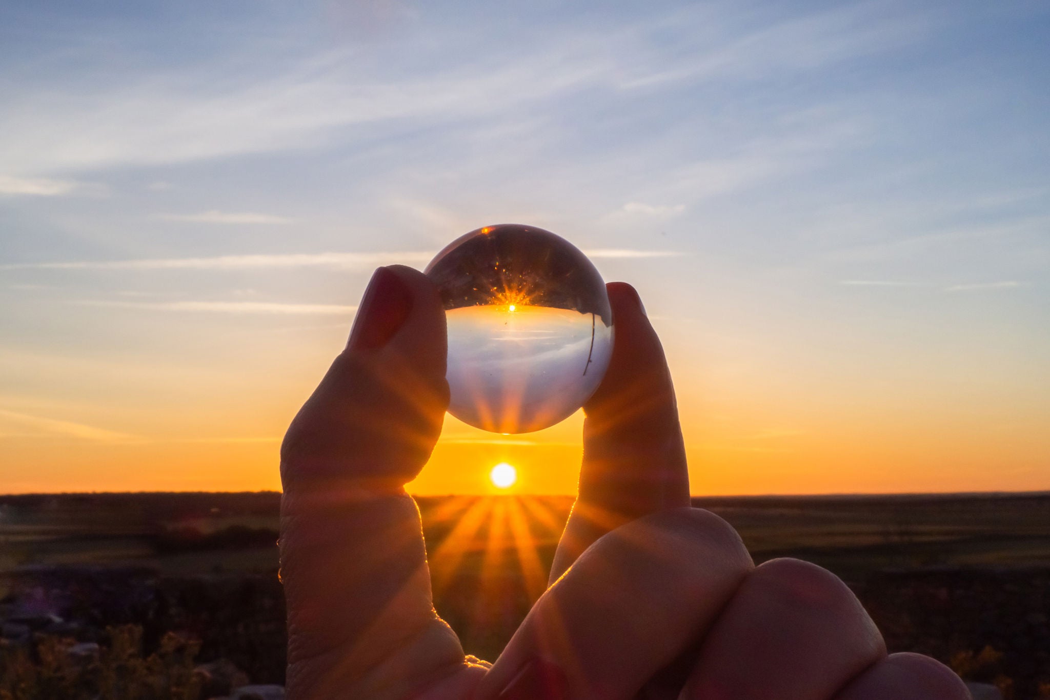 Solnedgang reflekteret i håndholdt krystalkugle