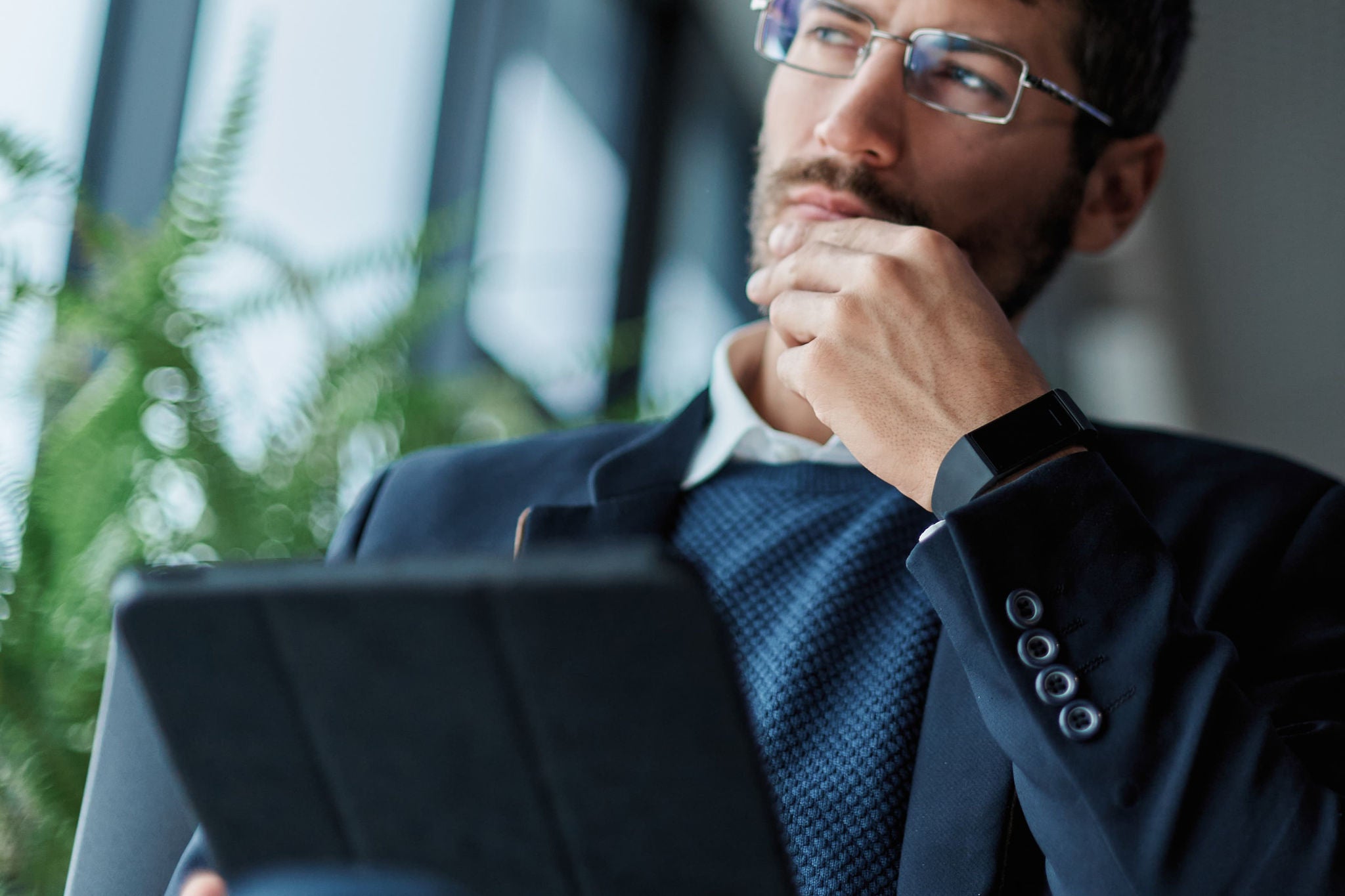 Person mit Tablet in einem Büro bei der Analyse digitaler Informationen.