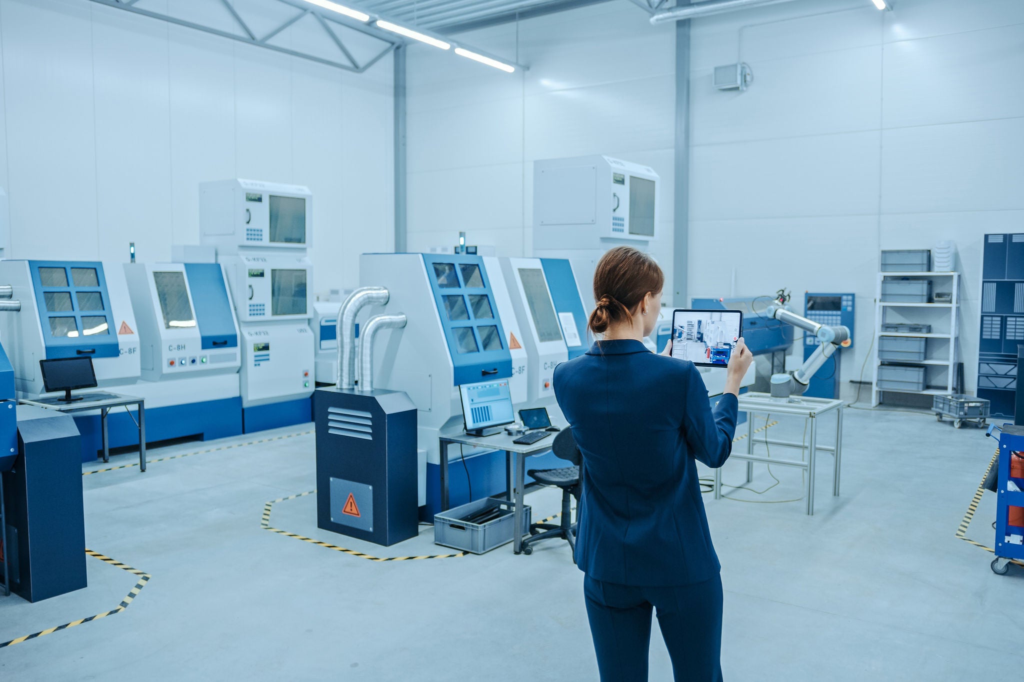 Mujer en sala con robots y computadoras