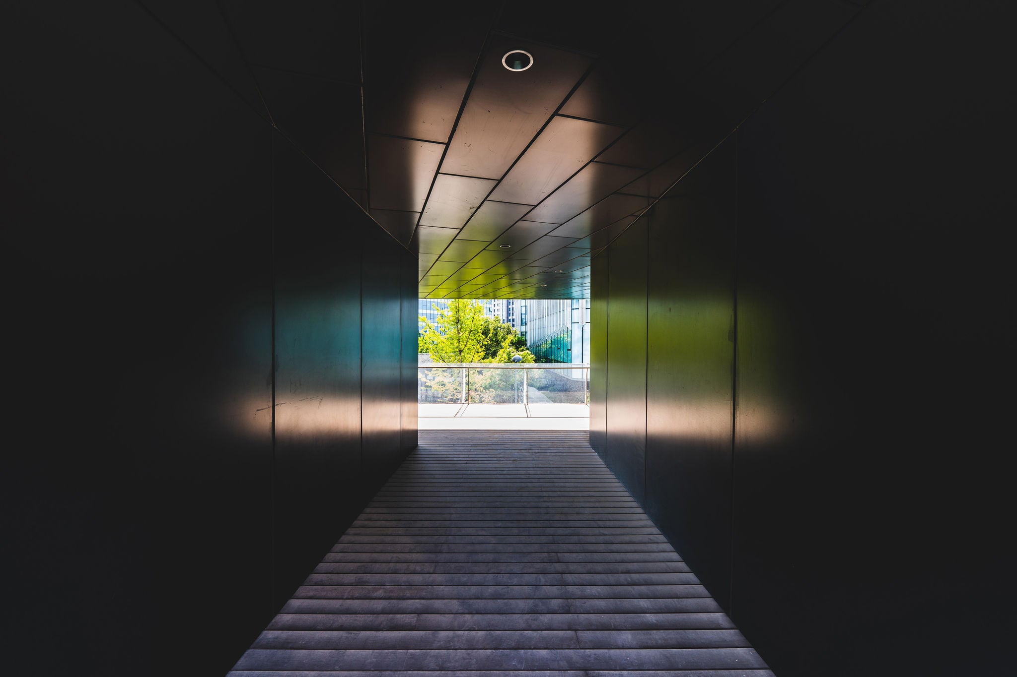 Dark corridor leading toward a bright outdoor space