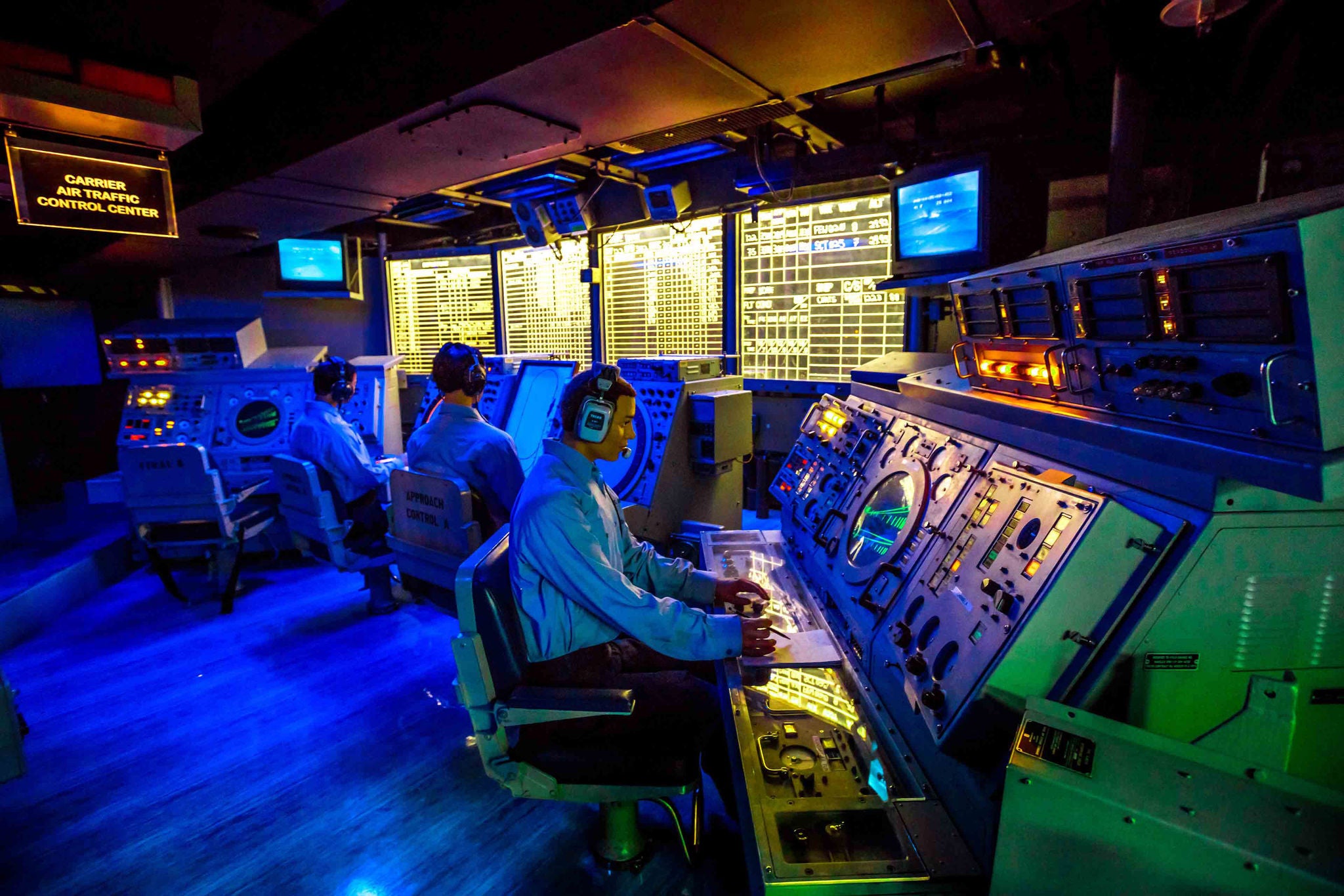 San Diego, Navy Pier, California, USA - JULY 31, 2018: soldier operators of detection and tracking room of the Battleship USS Midway at San Diego, Navy Historic museum. Dark mode with radar and sonar.