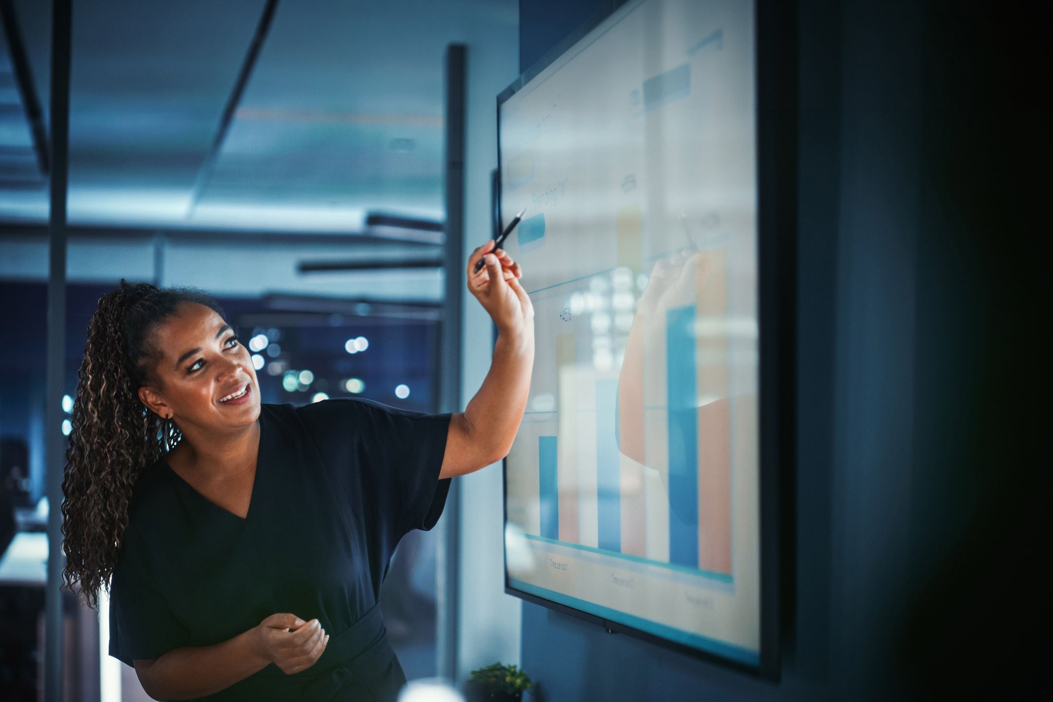 Company Operations Director Holds Sales Meeting Presentation for Employees and Executives. Creative Black Female Uses TV Screen with Growth Analysis; Charts; Ad Revenue. Work in Business Office.