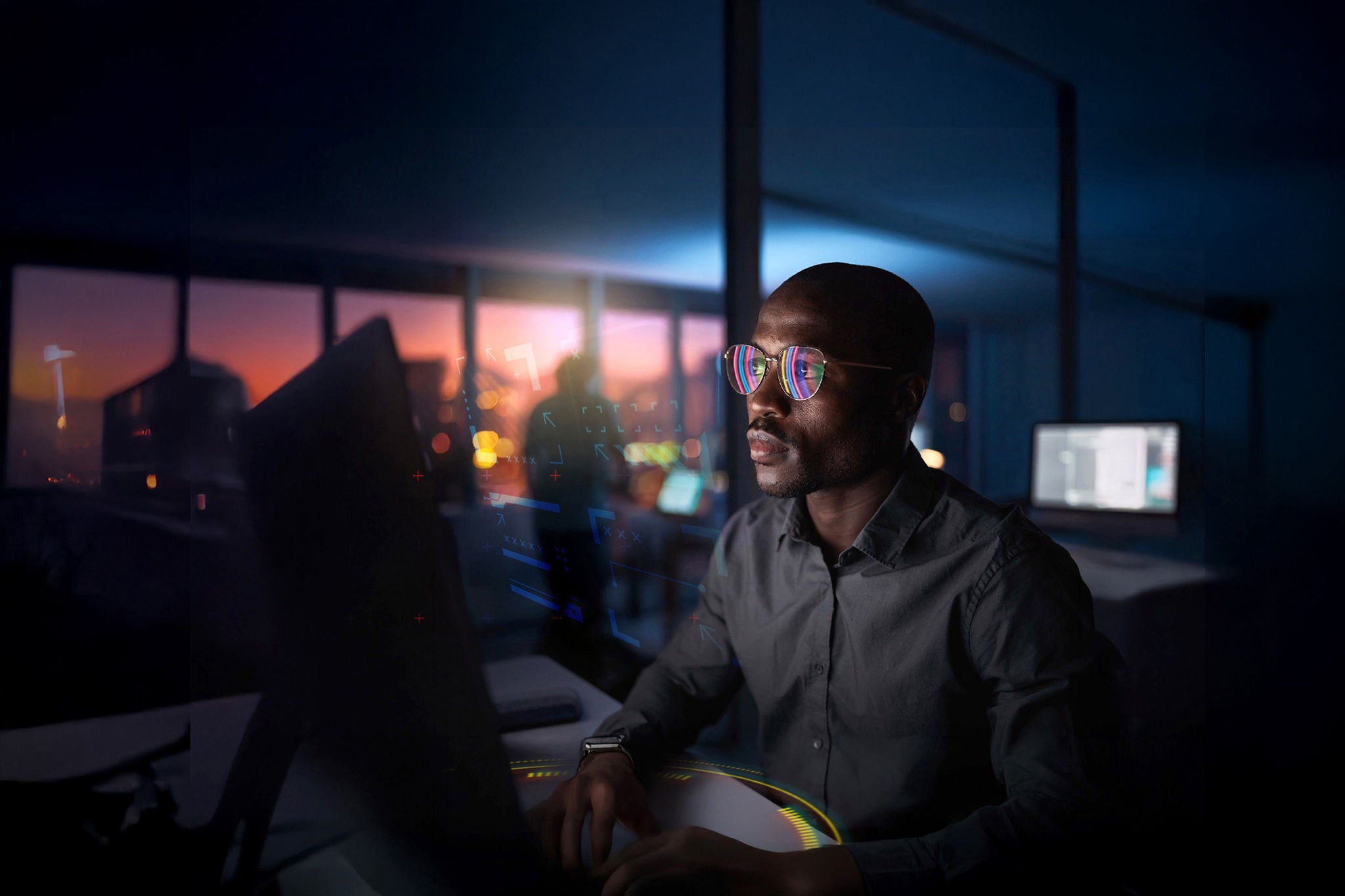 Person using computer with city lights view